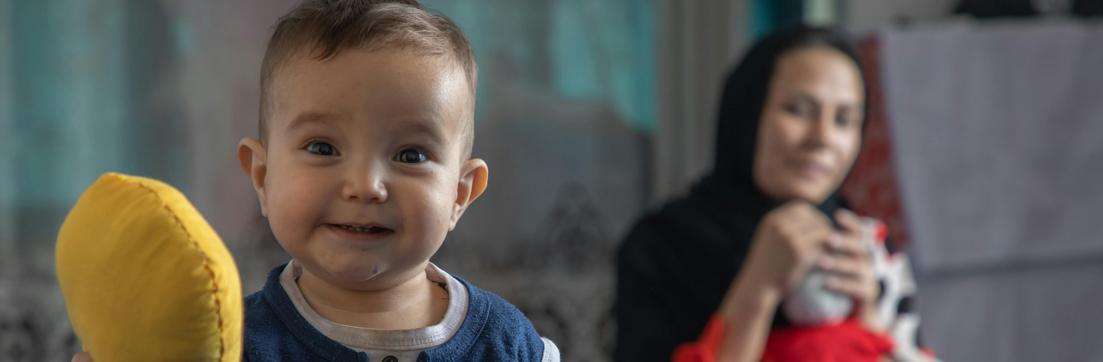 Nahid, 5 and Ali Mehran, 1 year old, are playing with the dolls at their home in Afghanistan