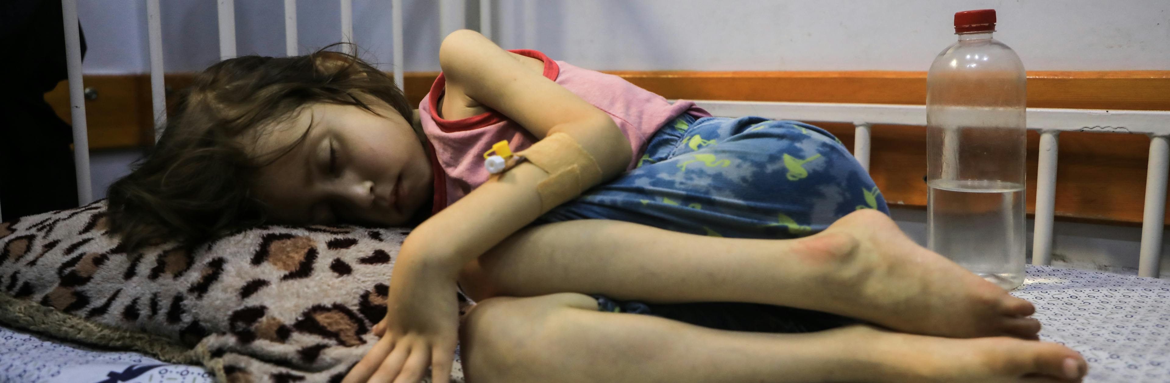 A child suffering from malnutrition lies on a bed in the Patient Society Hospital in Gaza City on 29 July 2025, during a visit by Ted Chaiban (not pictured), UNICEF Executive Director for Humanitarian Action and Supply Operations.