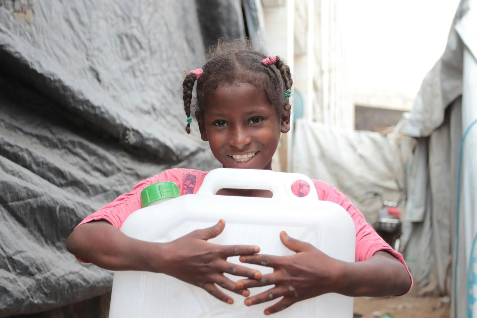 9-year-old Hayat Ali Amkam collects water in the Omar Bin Yasser camp in Aden, YEMEN.