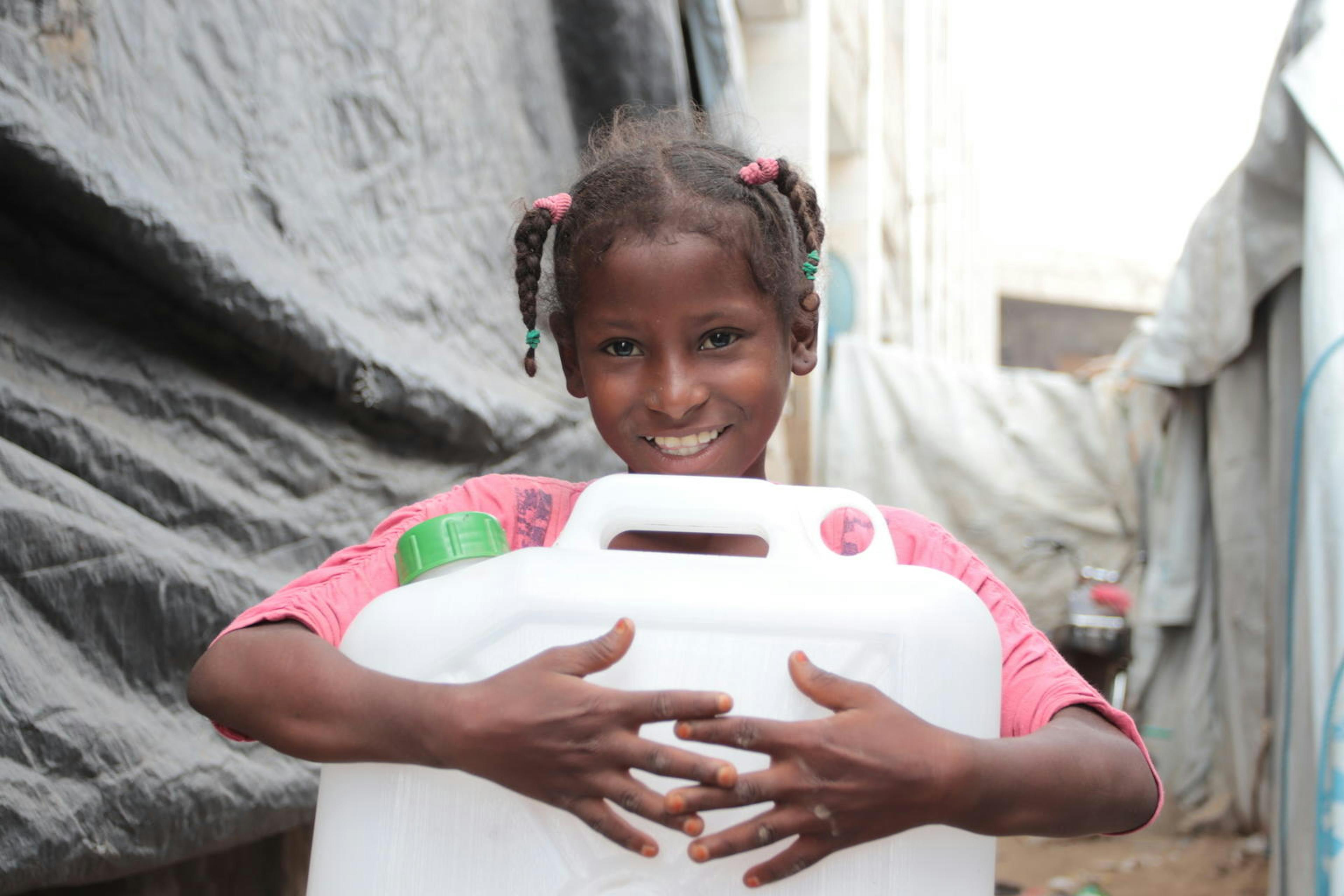 9-year-old Hayat Ali Amkam collects water in the Omar Bin Yasser camp in Aden, YEMEN.