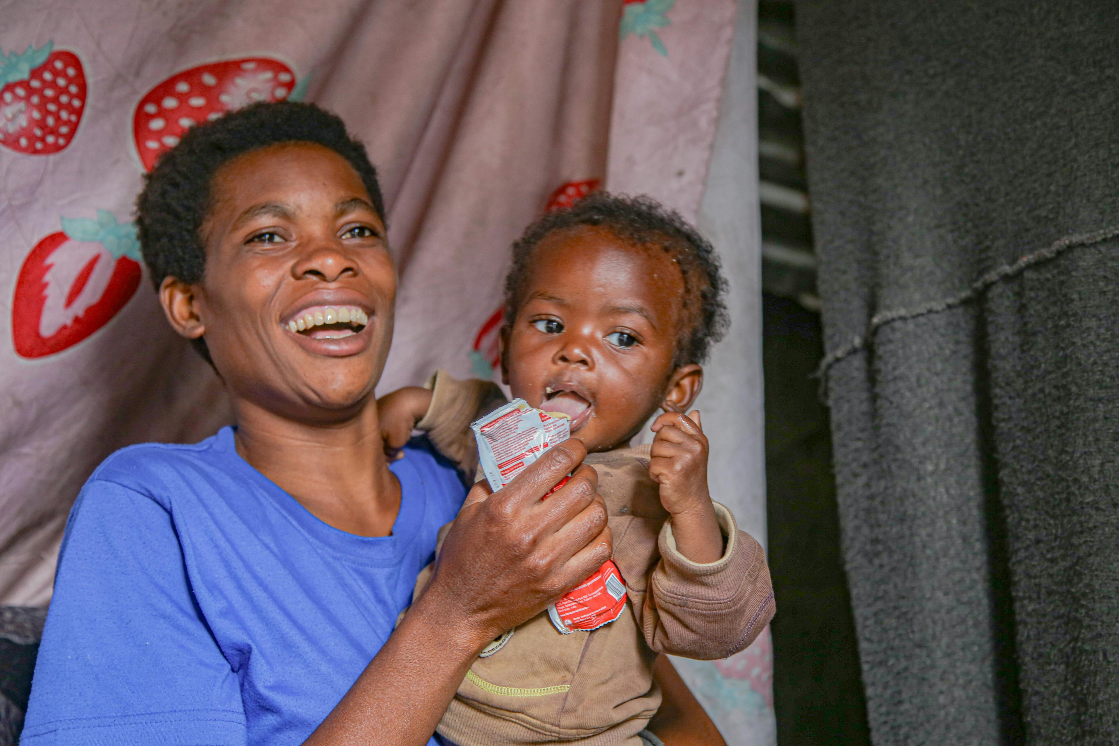 Akuzwe, 1, receives his daily ration of nutritional Plumpy’Nut paste in his mother Chucrani’s arms at their home in Goma, North Kivu province, DR Congo, on 19 March 2025.