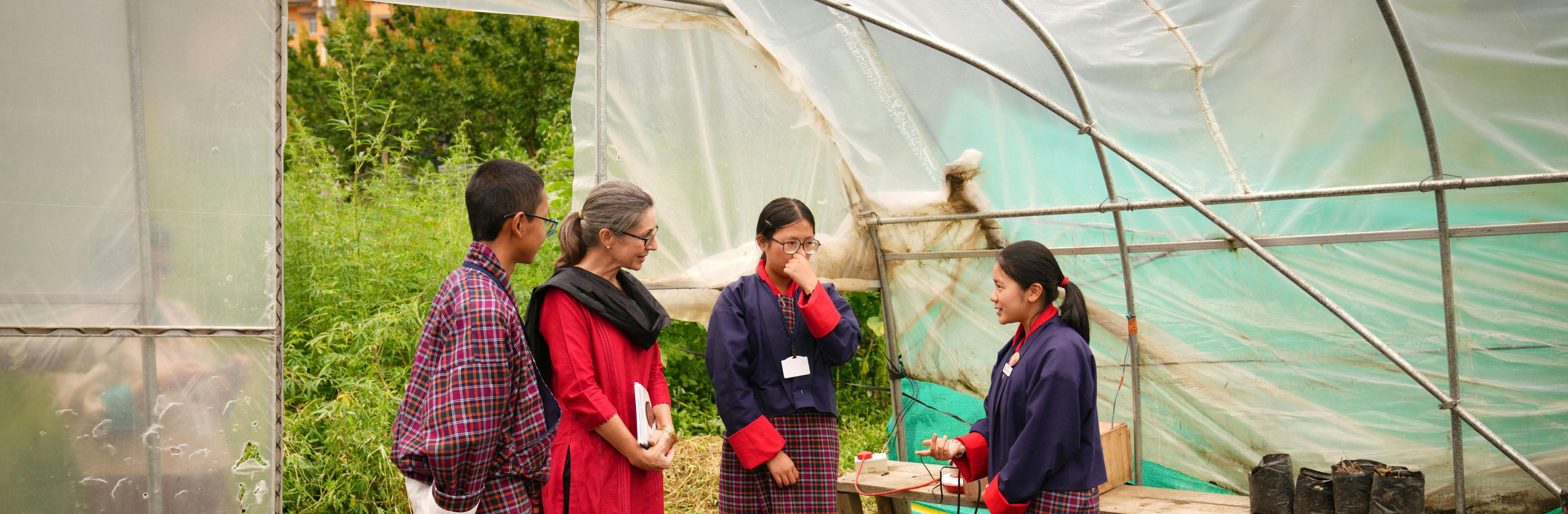 Students in Bhutan stand in their school greenhouse