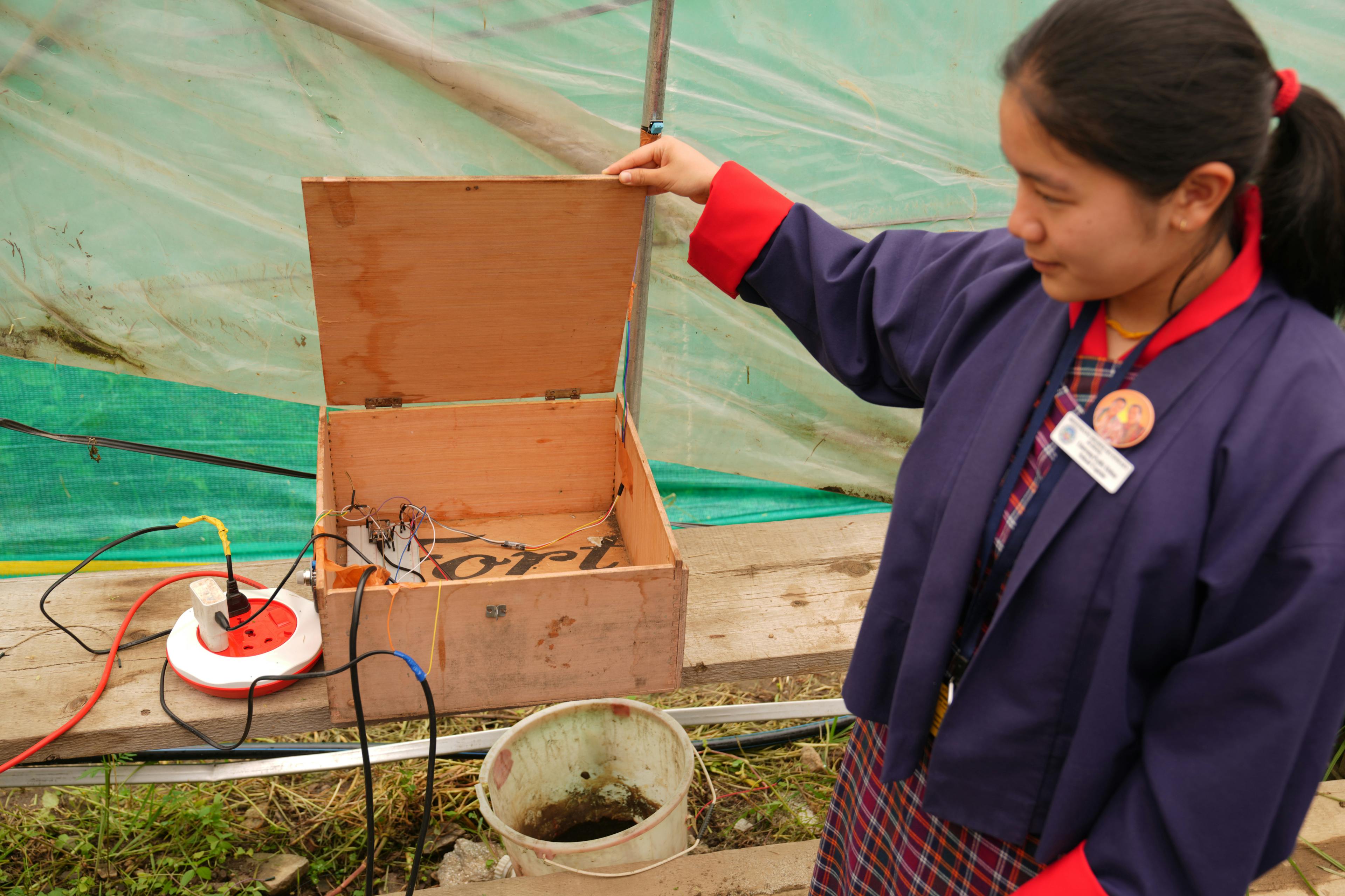 A student shows their greenhouse innovation