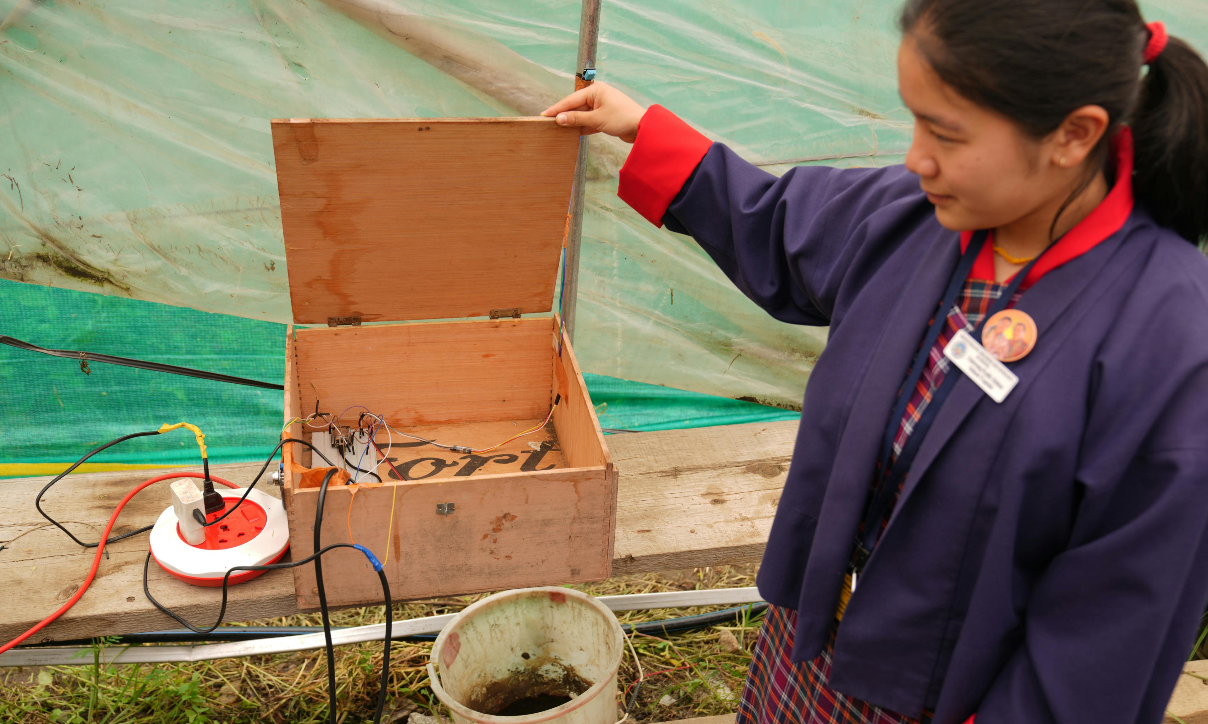 A student shows their greenhouse innovation