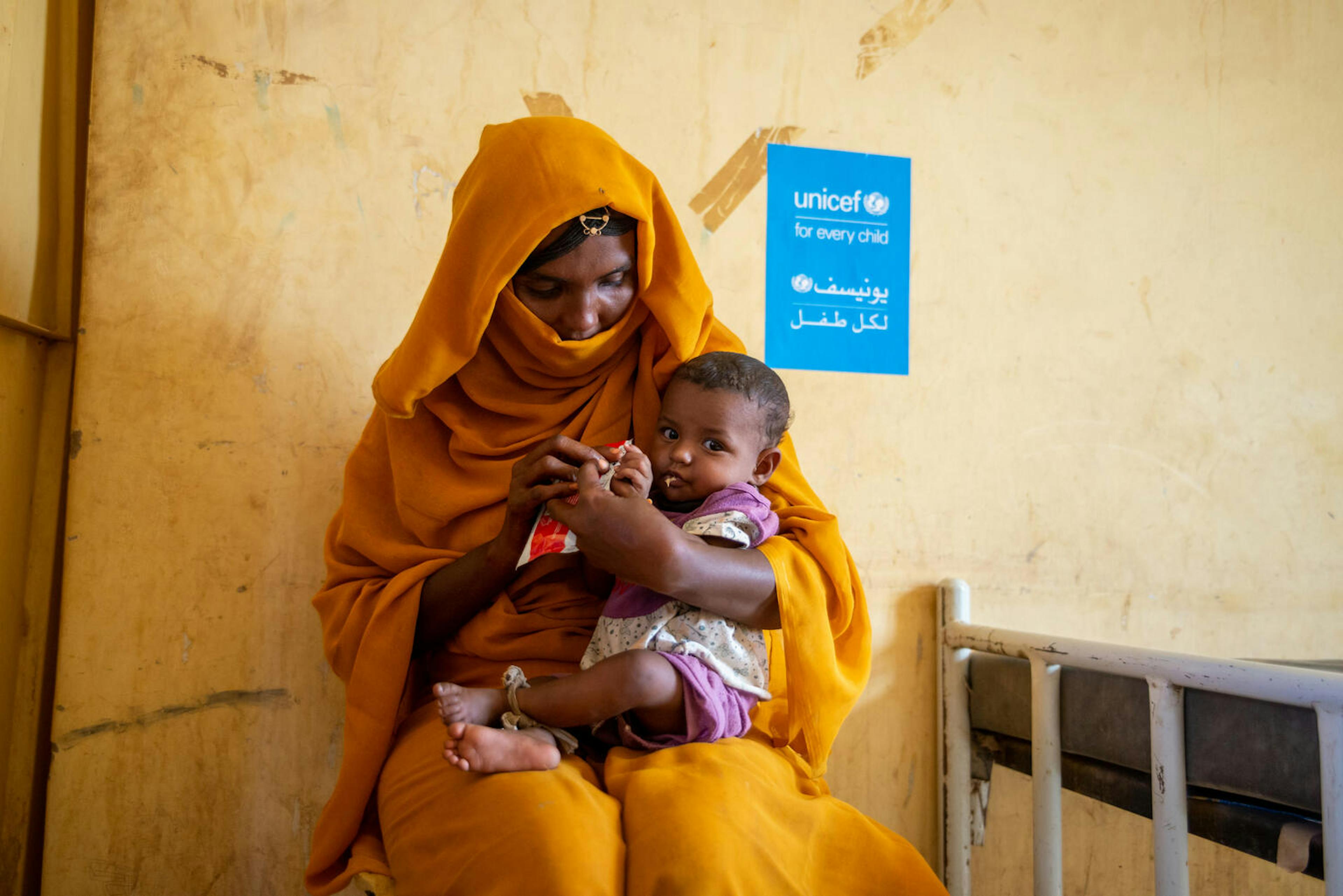 A mother feeds her child life-saving therapeutic food