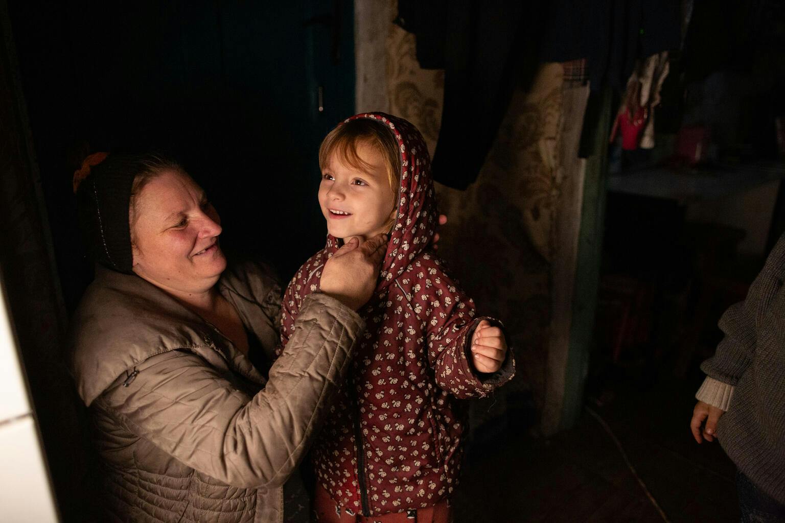 Svitlana dresses her daughter in the winter clothes received from UNICEF
