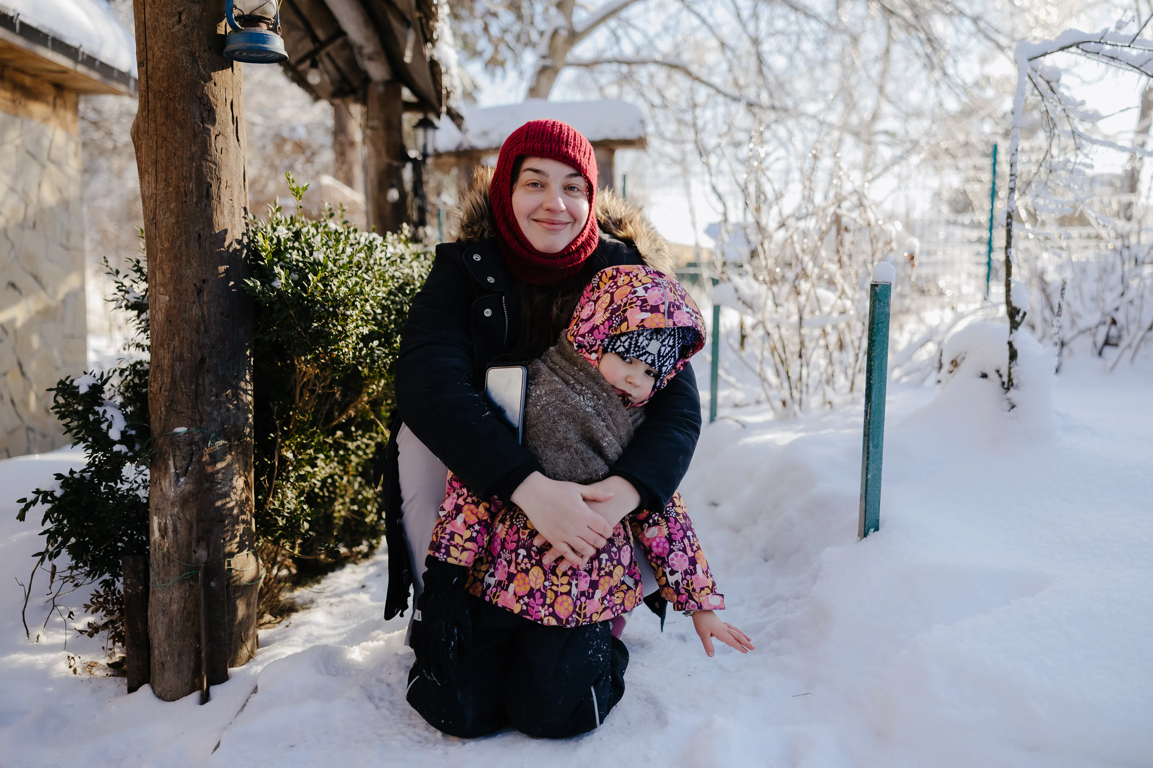 Mother-hugs-daughter-as-they-stand-out-in-the-snow
