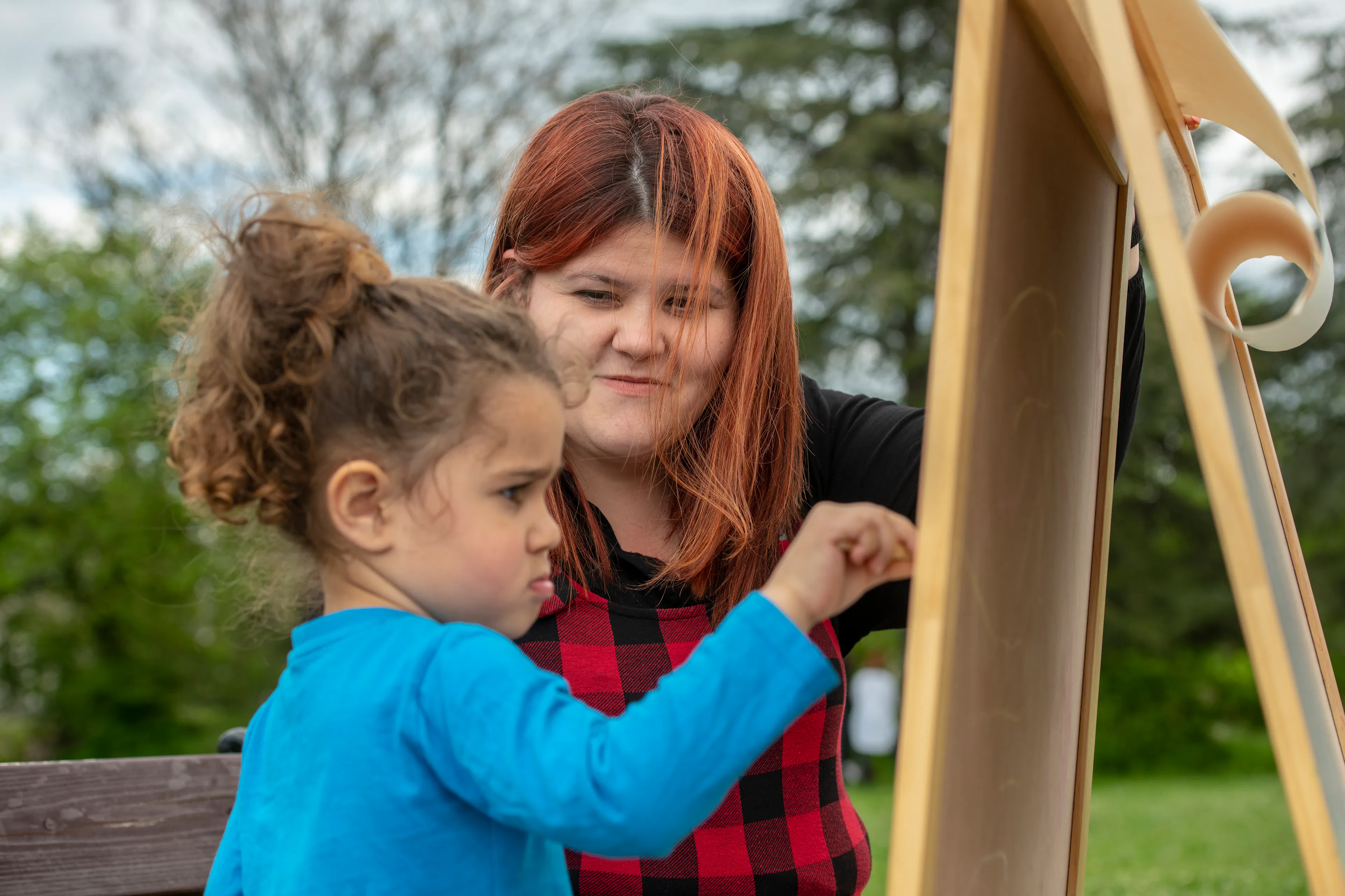 Child-wearing-blue-paints-with-her-guardian-watching-over-her