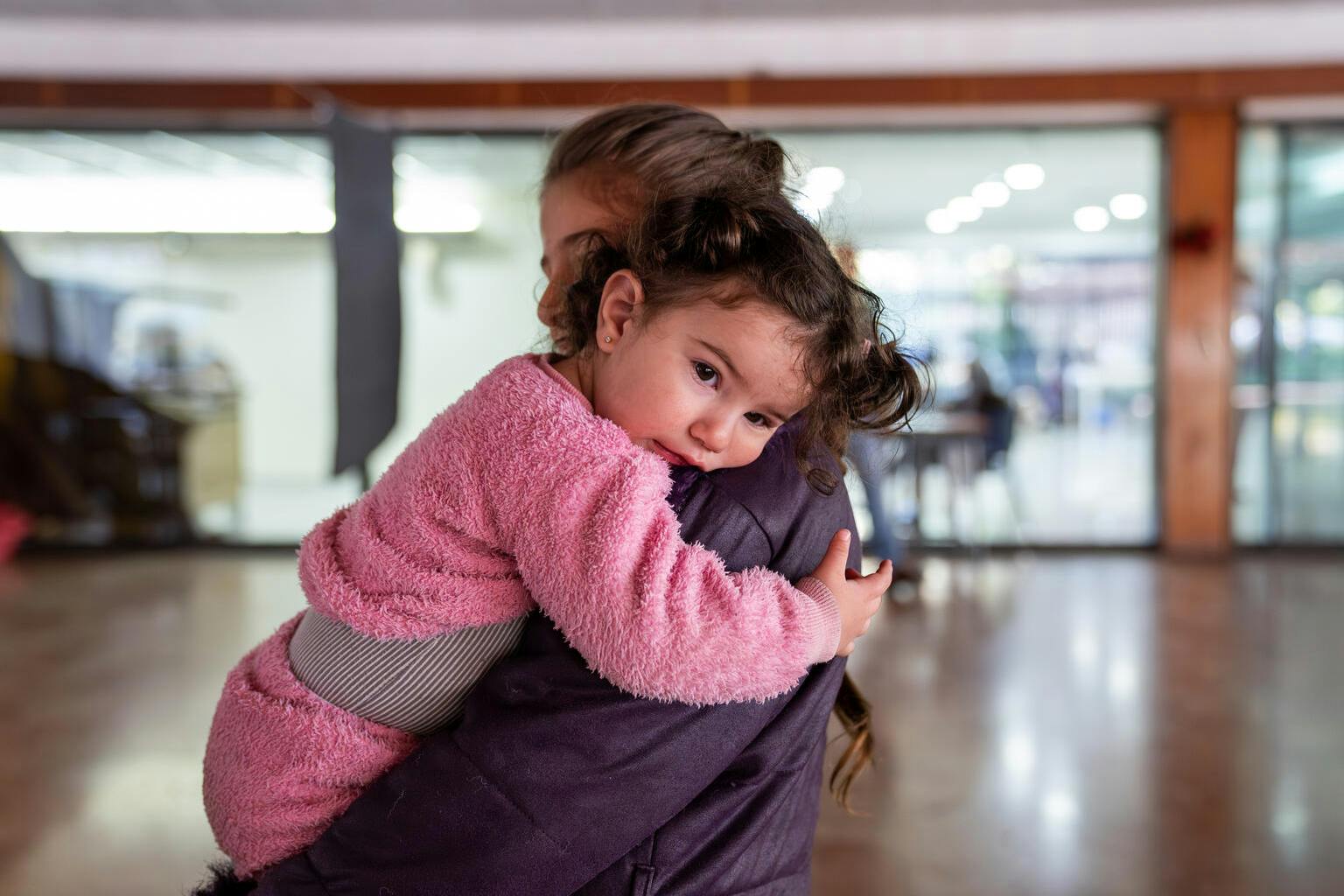 A young girl and her 10 years old sister stand in a public school turned into a shelter.
