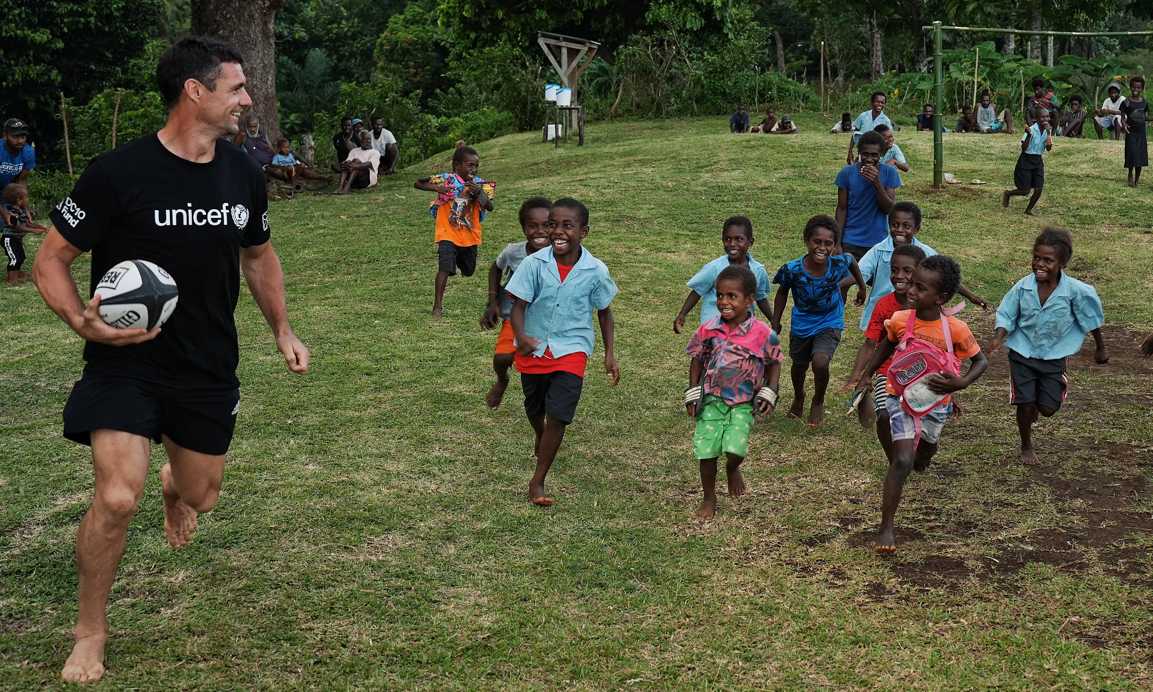 Dan Carter plays rugby with school kids in the Pacific.