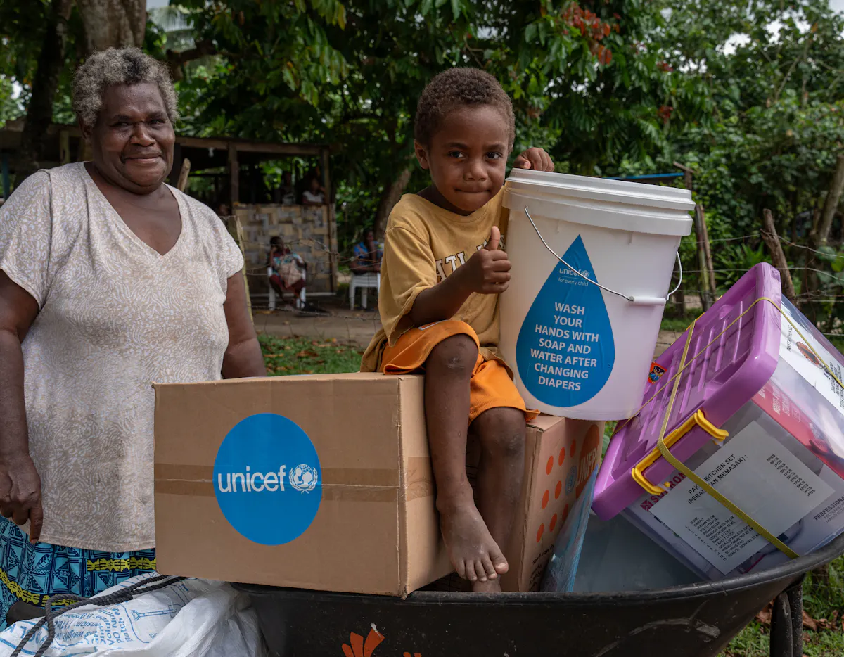 Jacklyn, grandmother and her 4 year old grandson Johnathan with their families emergency kit distributed by UNICEF Vanuatu WASH officer Sandrine alongside partners to families in the Erakor Bridge community after the Earthquake.