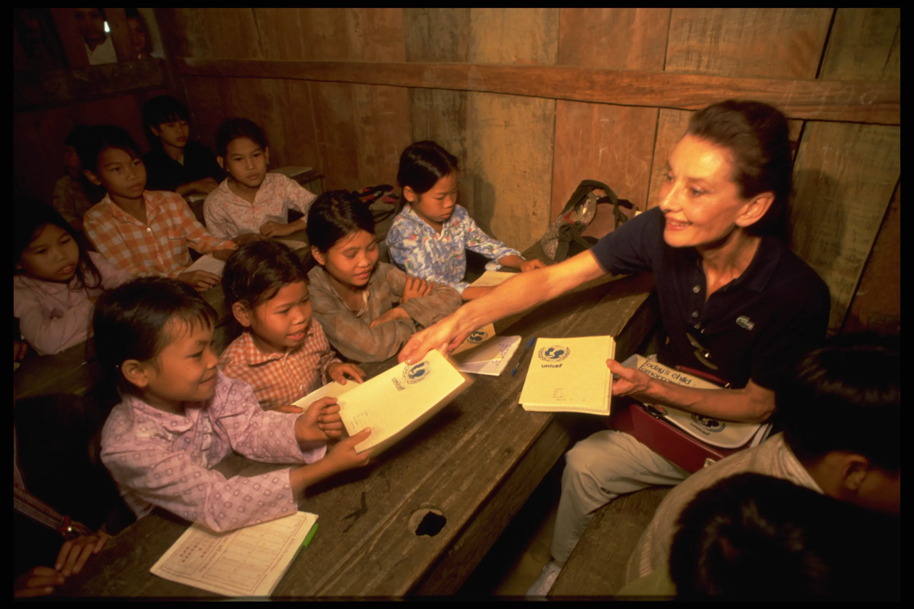 Audrey Hepburn distributes UNICEF-supplied exercise books to school children of the Dao Tay hilltribes in remote Hoang Lien Son Province in Northern Vietnam.