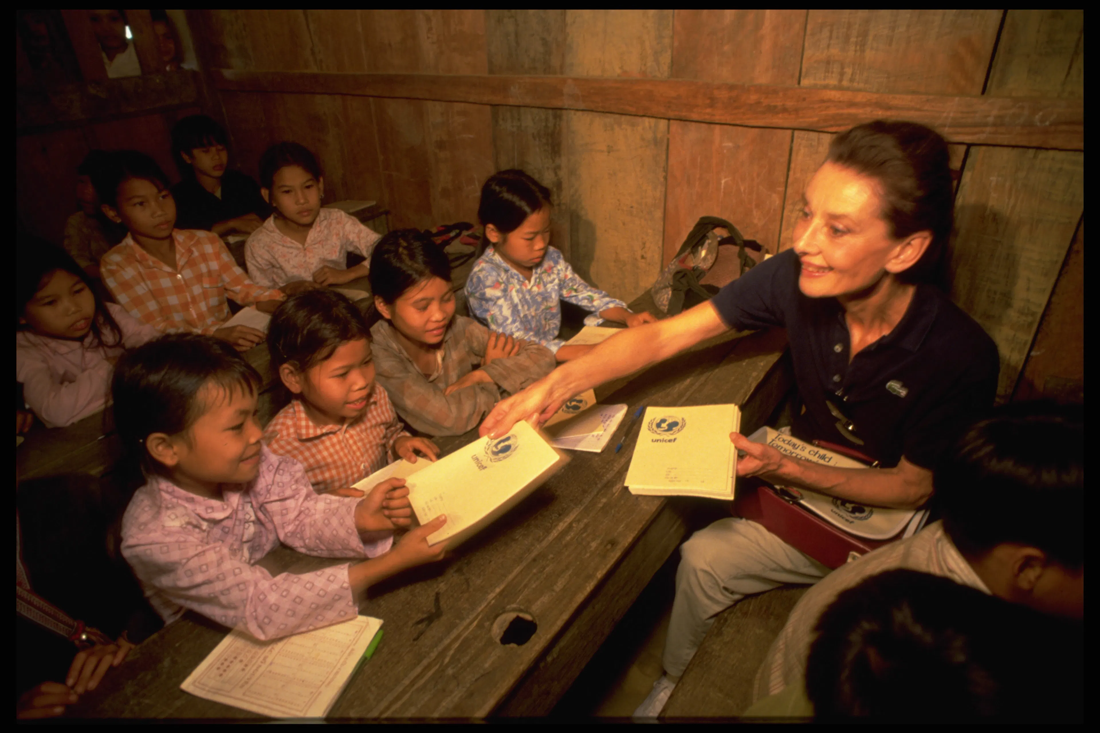 Audrey Hepburn distributes UNICEF-supplied exercise books to school children of the Dao Tay hilltribes in remote Hoang Lien Son Province in Northern Vietnam.