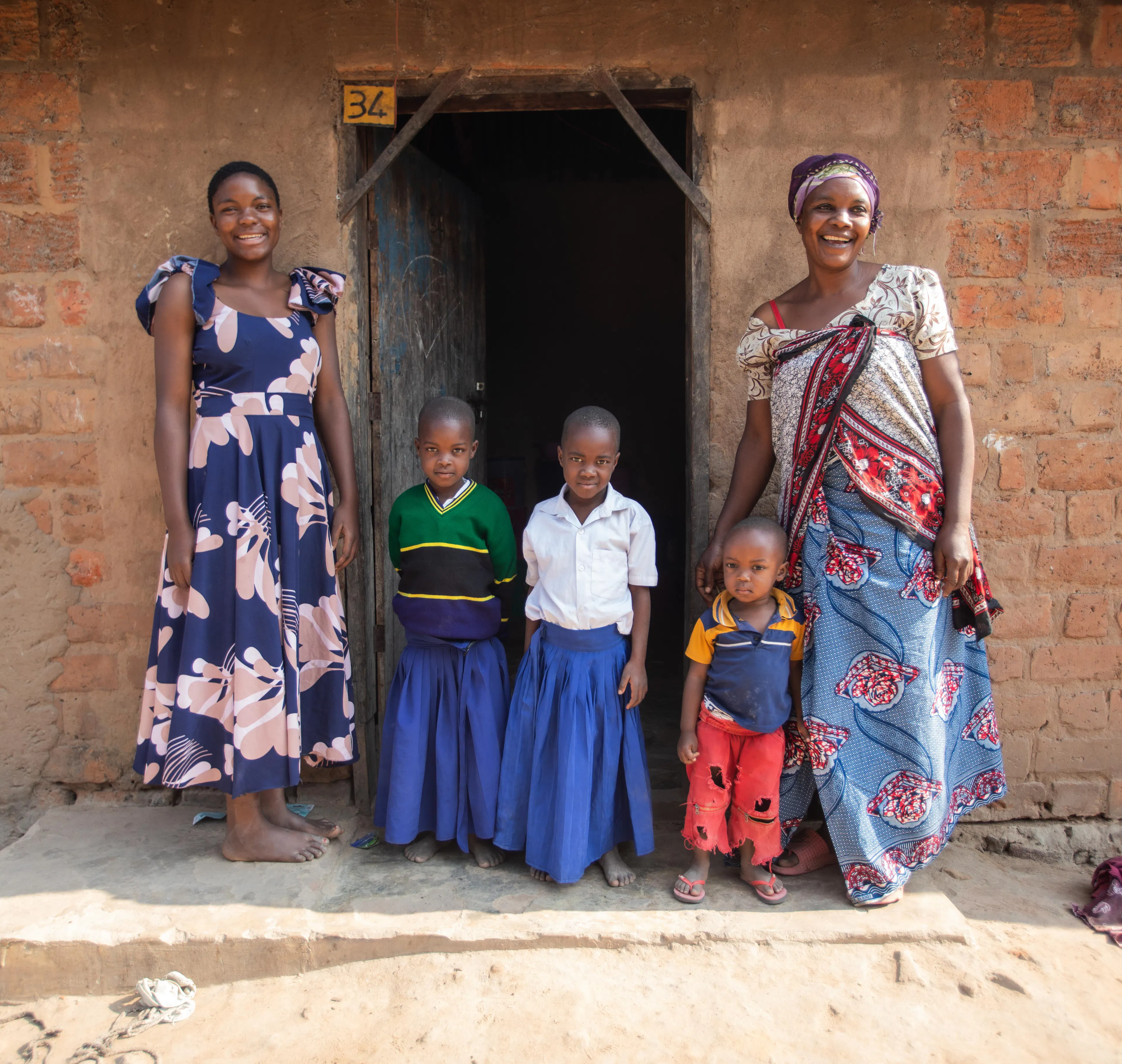 Antini Mahepa (left), 17, stands outside her home with her siblings, Pendo Ibrahim (middle left), 7, Mariam Ibrahim (middle), 9, Majati Ibrahim (middle right), 6, and her mother, Koretha Mahepa Mkonongo (right), 48, in Malagalasi Village located in the Uvinza District of the Kigoma Region in Tanzania.