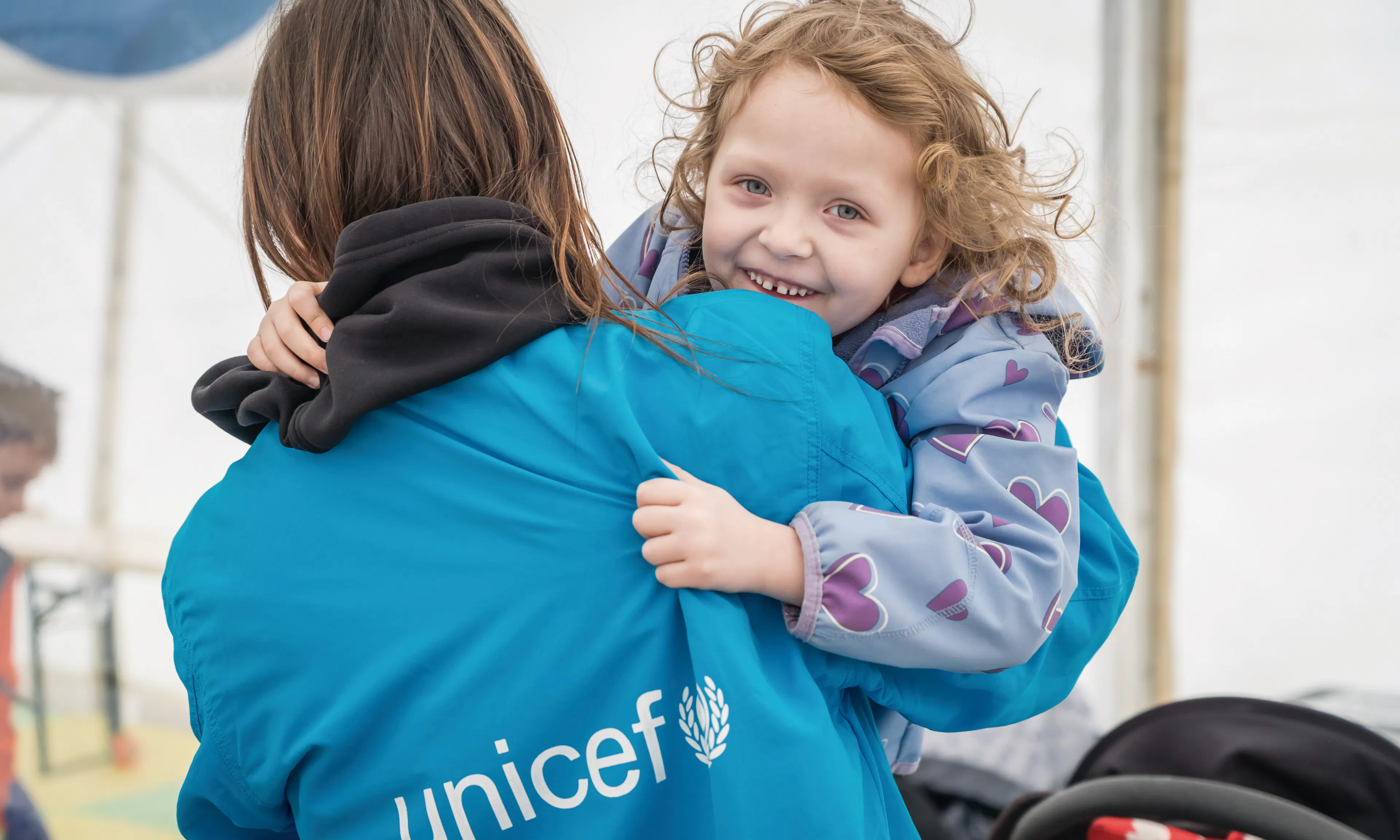 In Isaccea border crossing, Romania, 5-year-old Emma plays with a UNICEF staff member. Emma, her mother Yulia, and her little brother arrived at the hub after traveling from Odessa, Ukraine.
