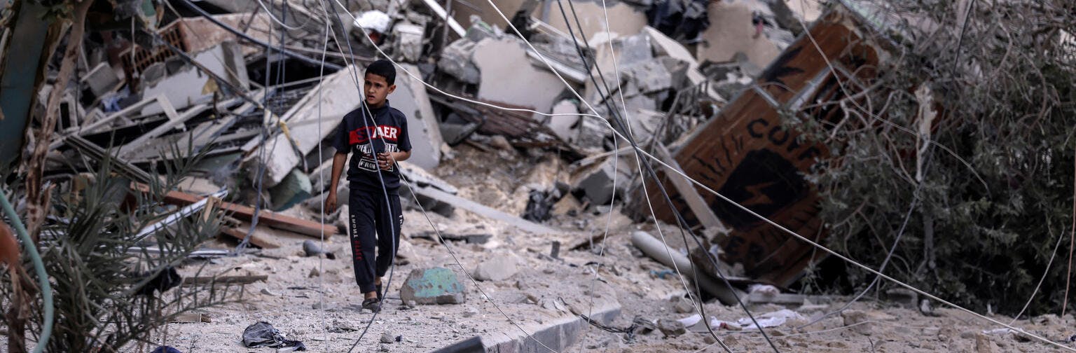 Young boy walks amid the rubble of a building destroyed by Israeli air strikes in Gaza City