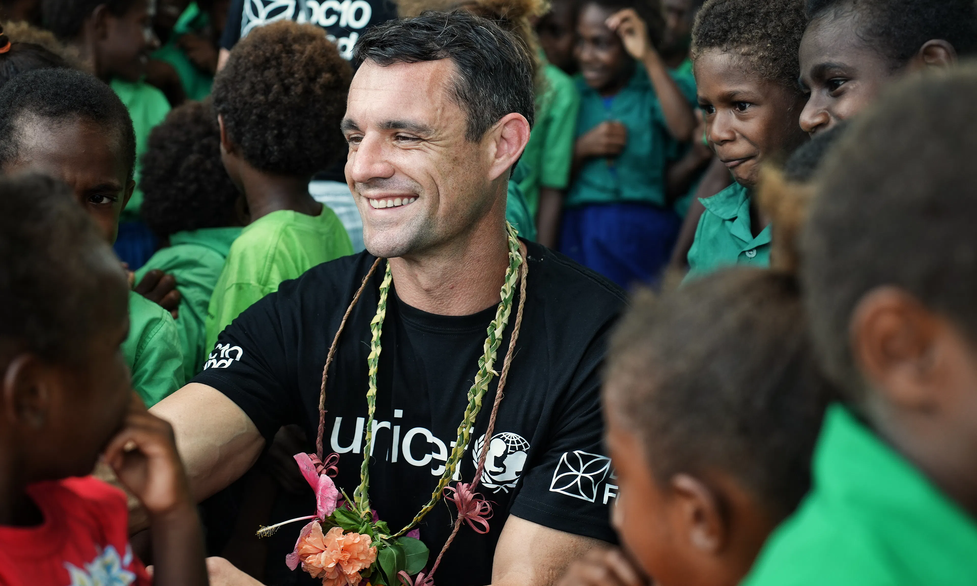 UNICEF Aotearoa New Zealand ambassador Dan Carter smiles with school children in Vanuatu