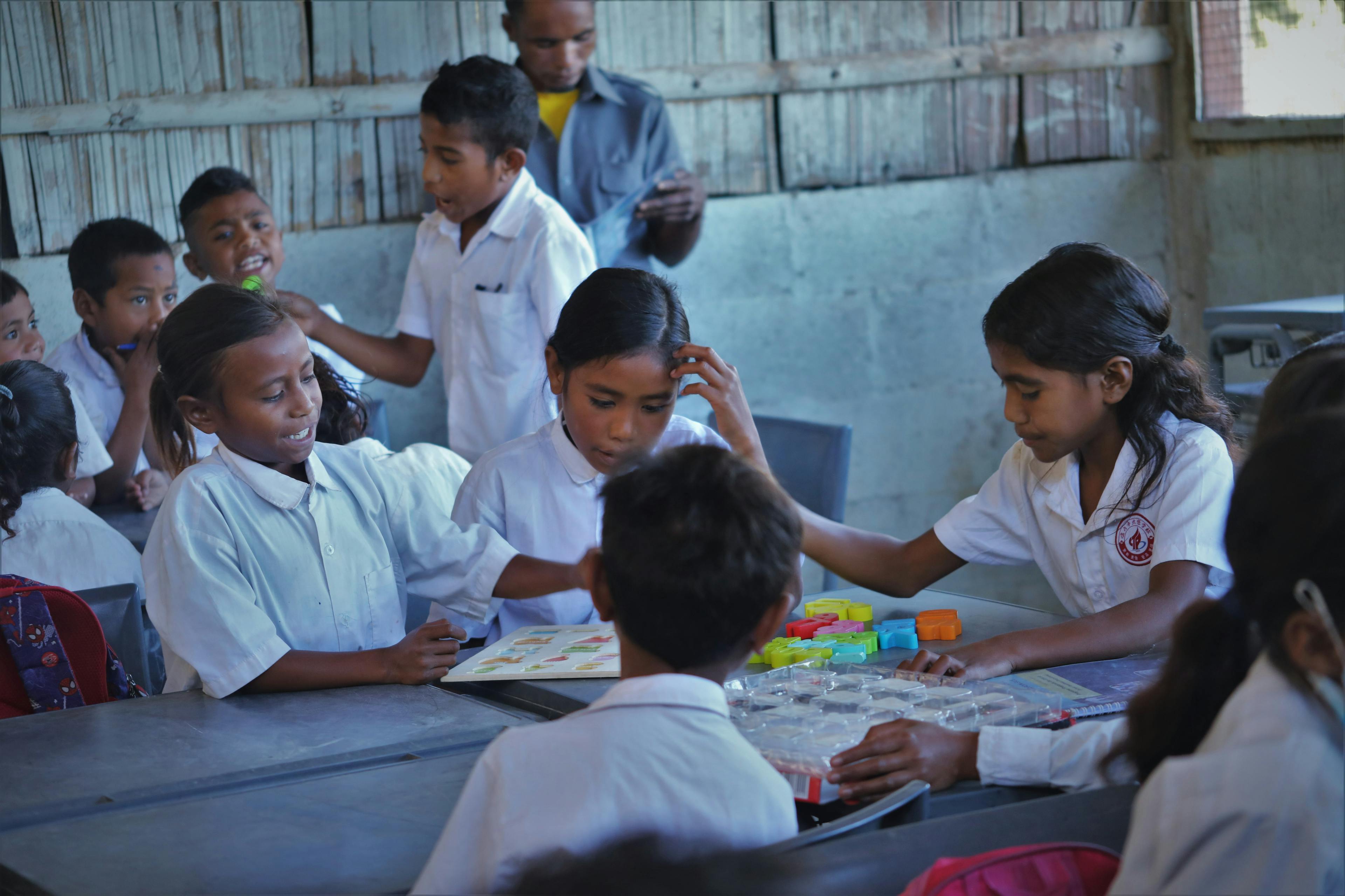 Children at BF Catrai Kraik Primary School using letter blocks to learn the alphabet.