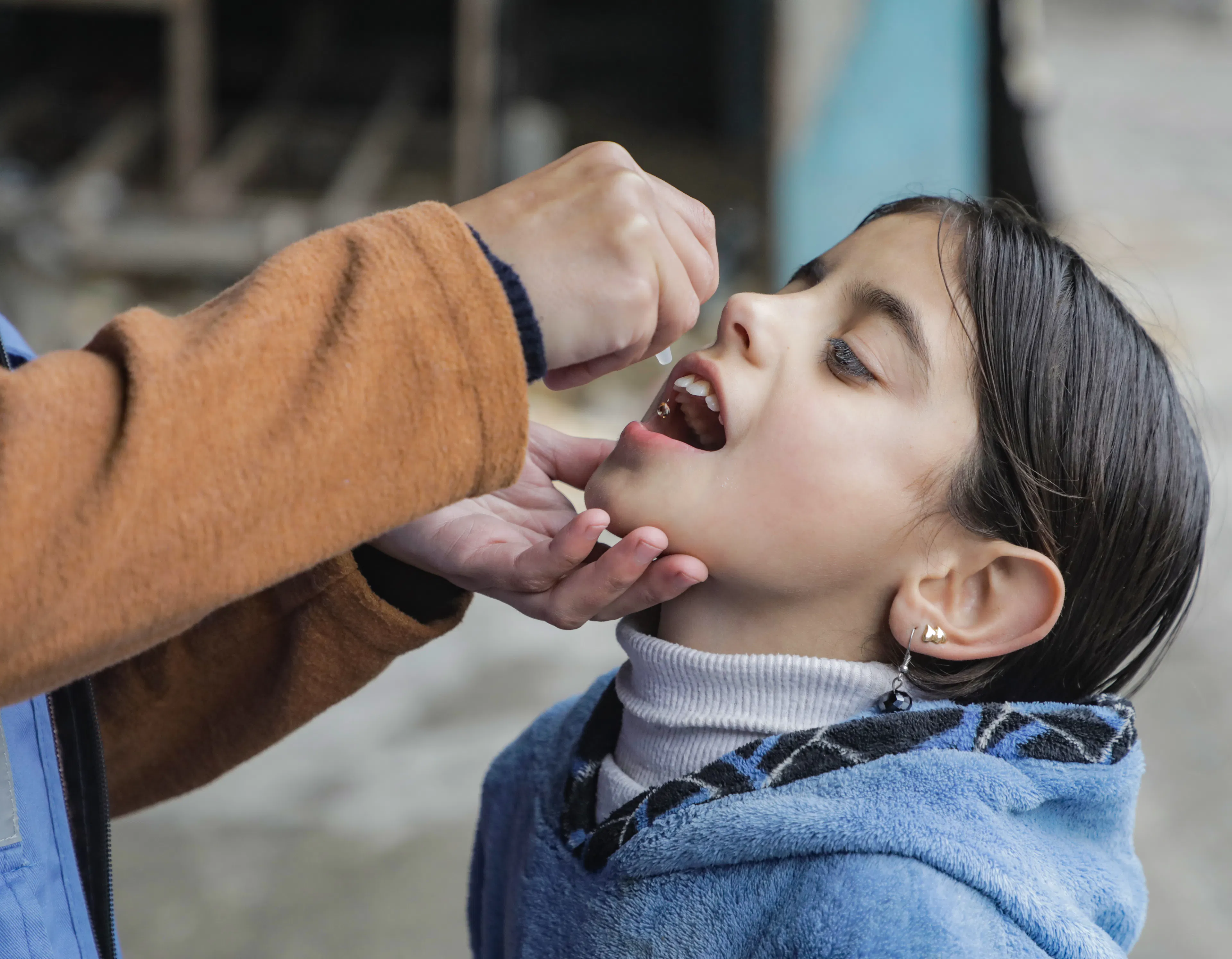 A child receives a polio vaccine, at a school in Beach camp in Gaza city, as part of a UNICEF vaccination campaign.