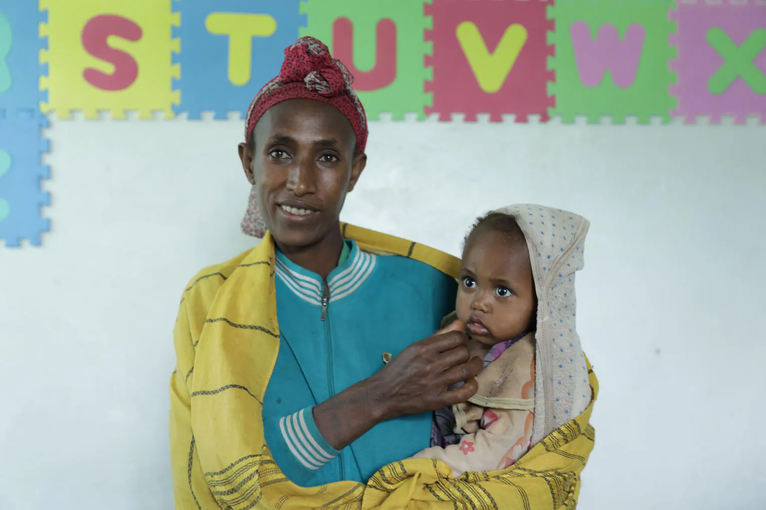 Bikile Milkessa waiting to get her baby girl Hawi Tamene vaccinated at Ginchi health post