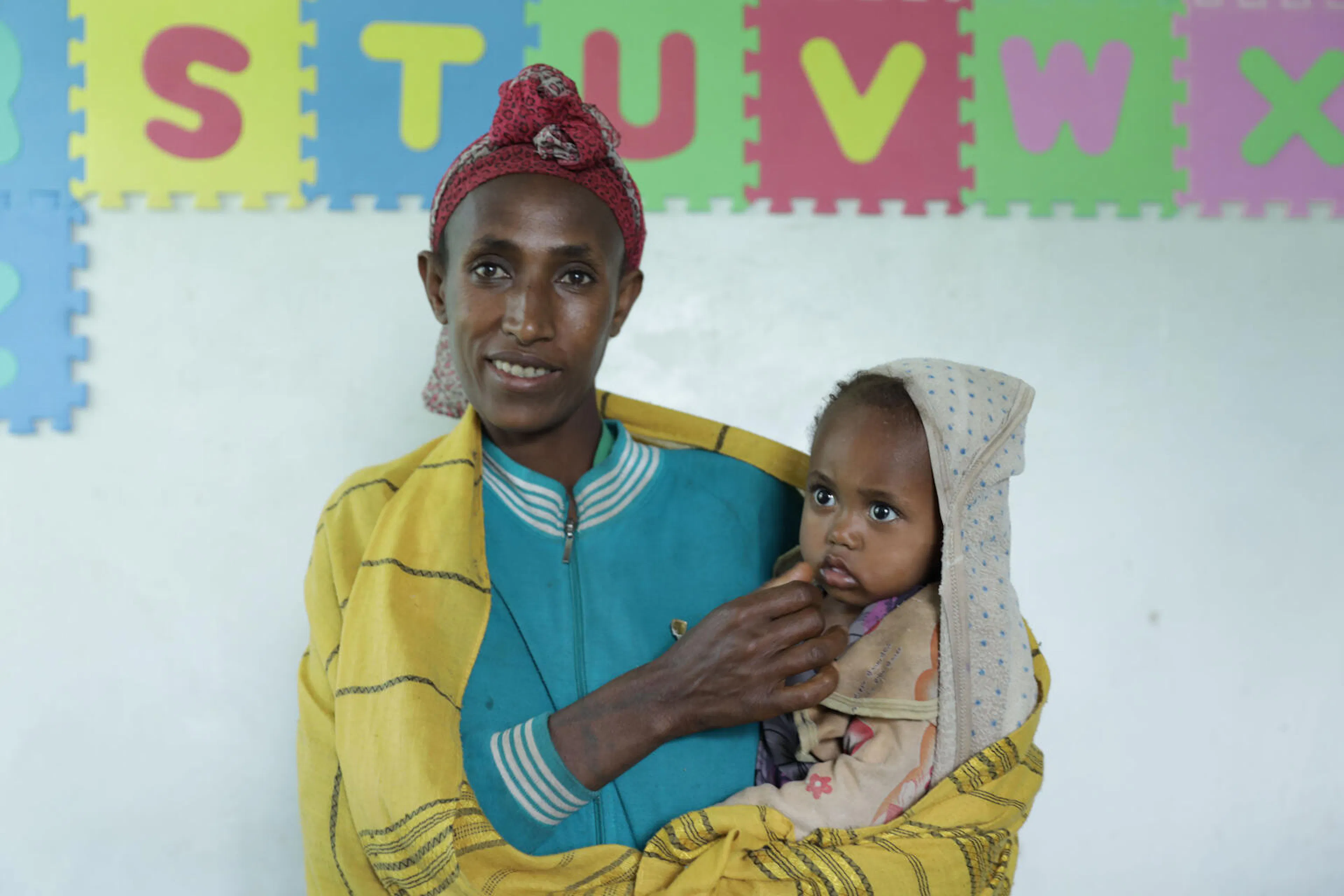 Bikile Milkessa waiting to get her baby girl Hawi Tamene vaccinated at Ginchi health post