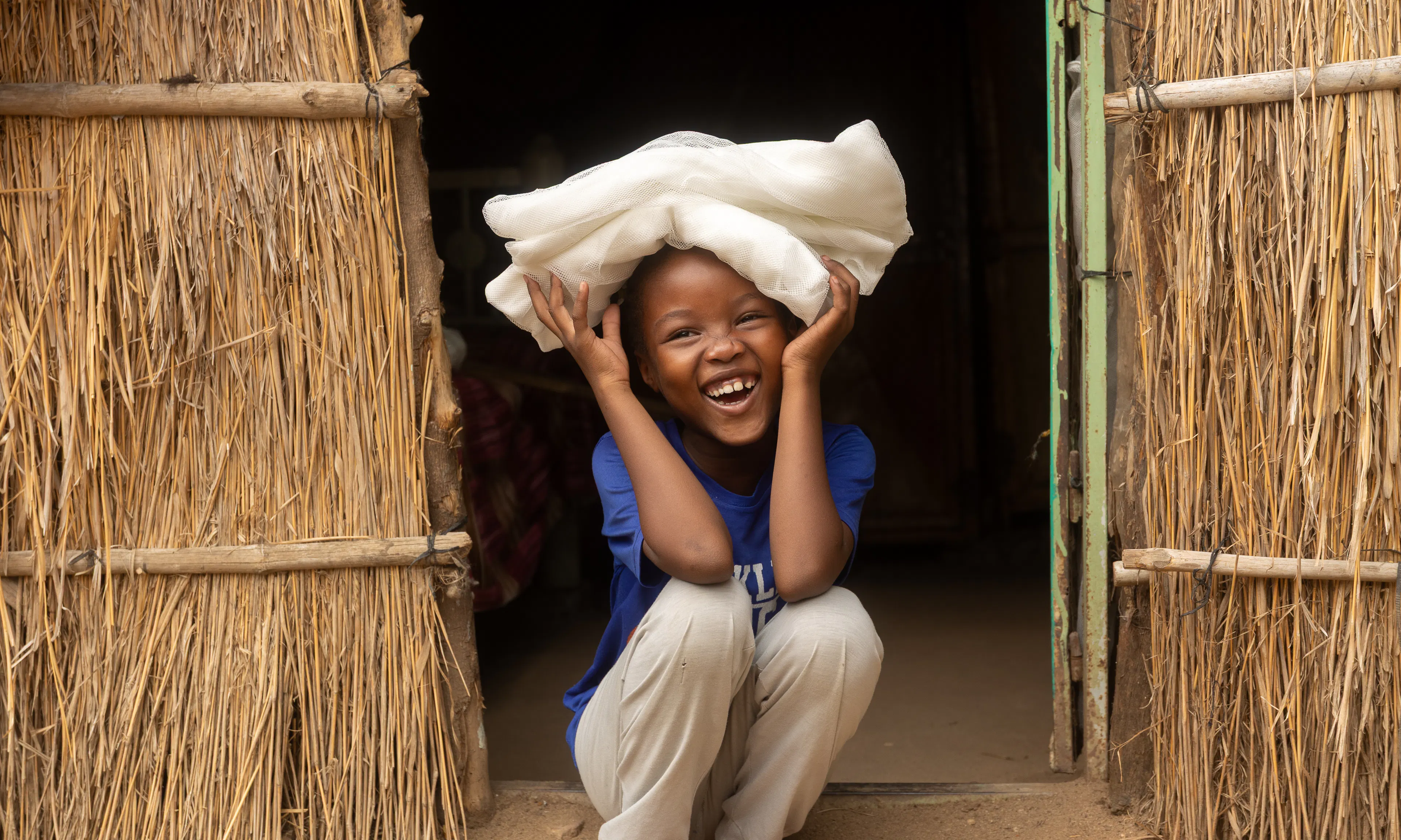 On 30 May, a child smiles after receiving a new bed net at her home in Arabee neighbourhood, in Damazine, Blue Nile state.