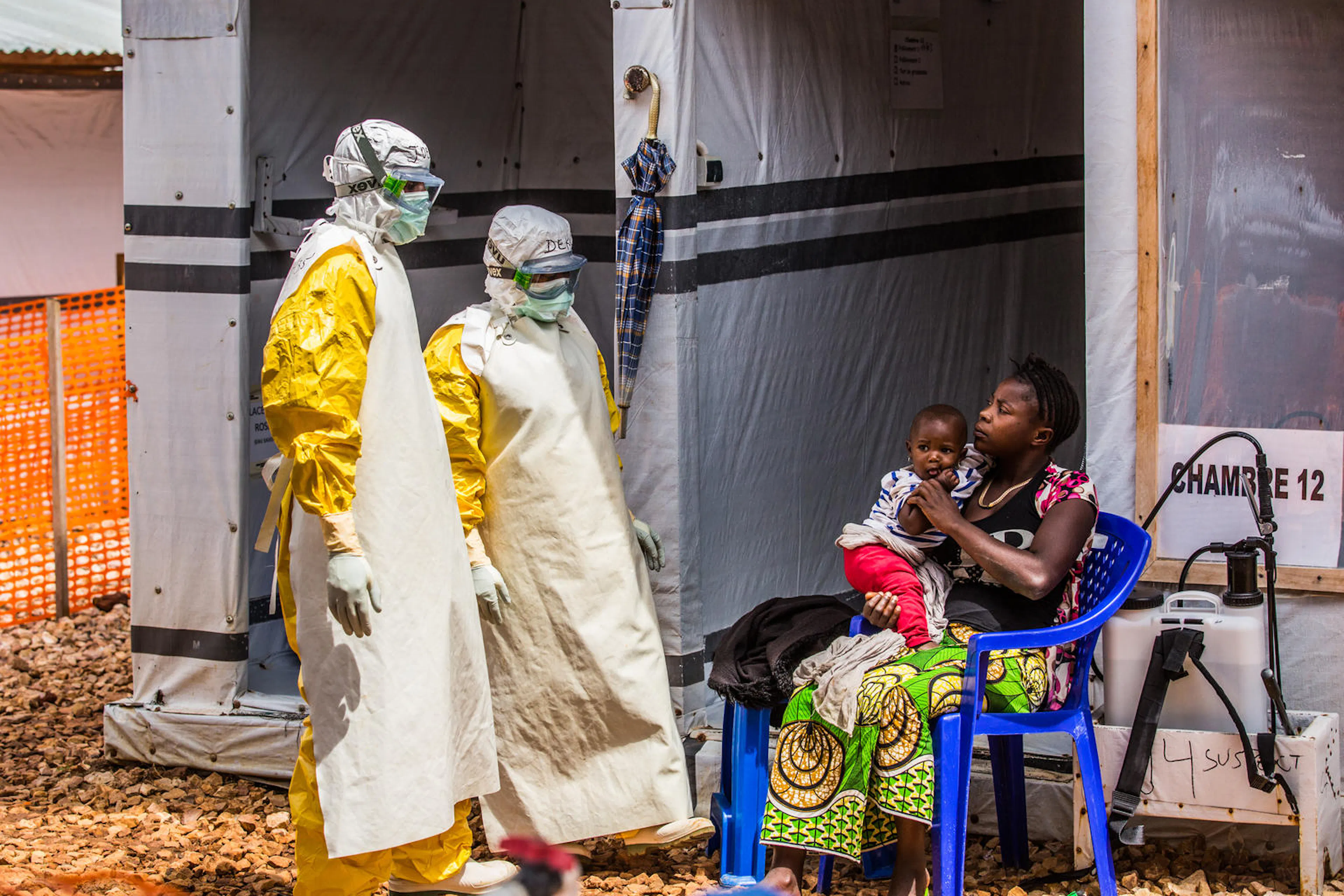 Health workers come to visit Katungo Kasobolo, 31, as she rests with  her daughter Kahindo Claudette, 1, in the quarantine area of the Ebola Teatment Centre of Butembo, North-Kivu province, Democratic Republic of Congo