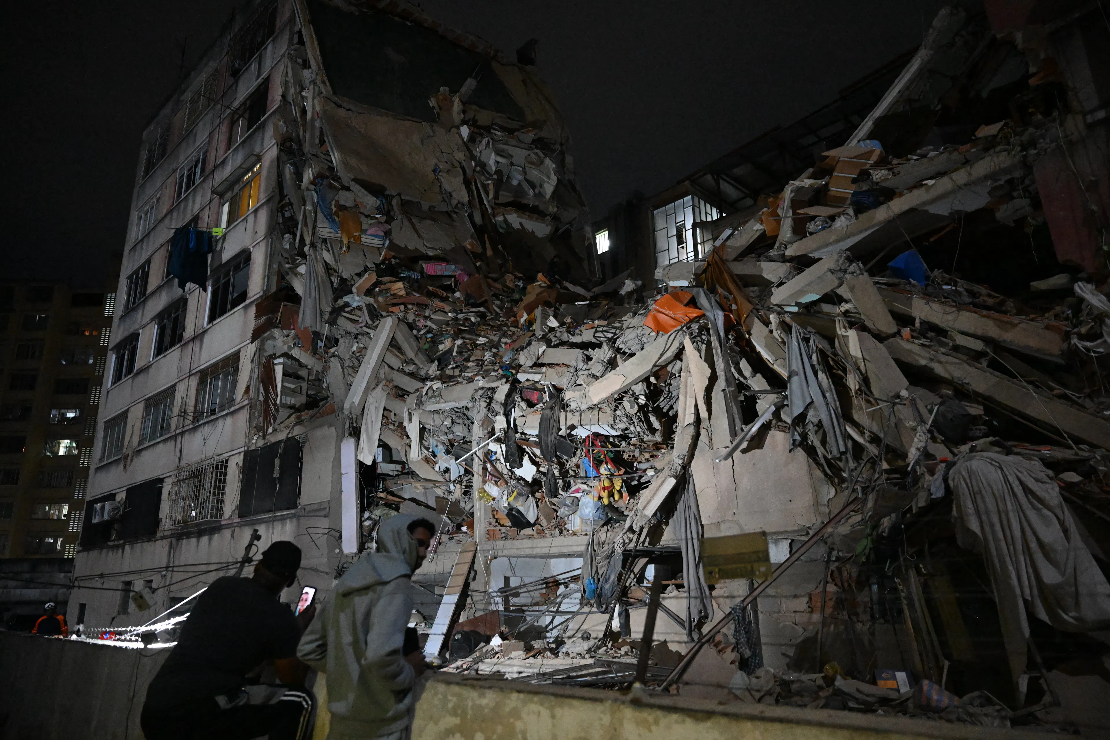 People look at a collapsed building in the Altamira neighbourhood following an earthquake in Caracas on June 24, 2026.