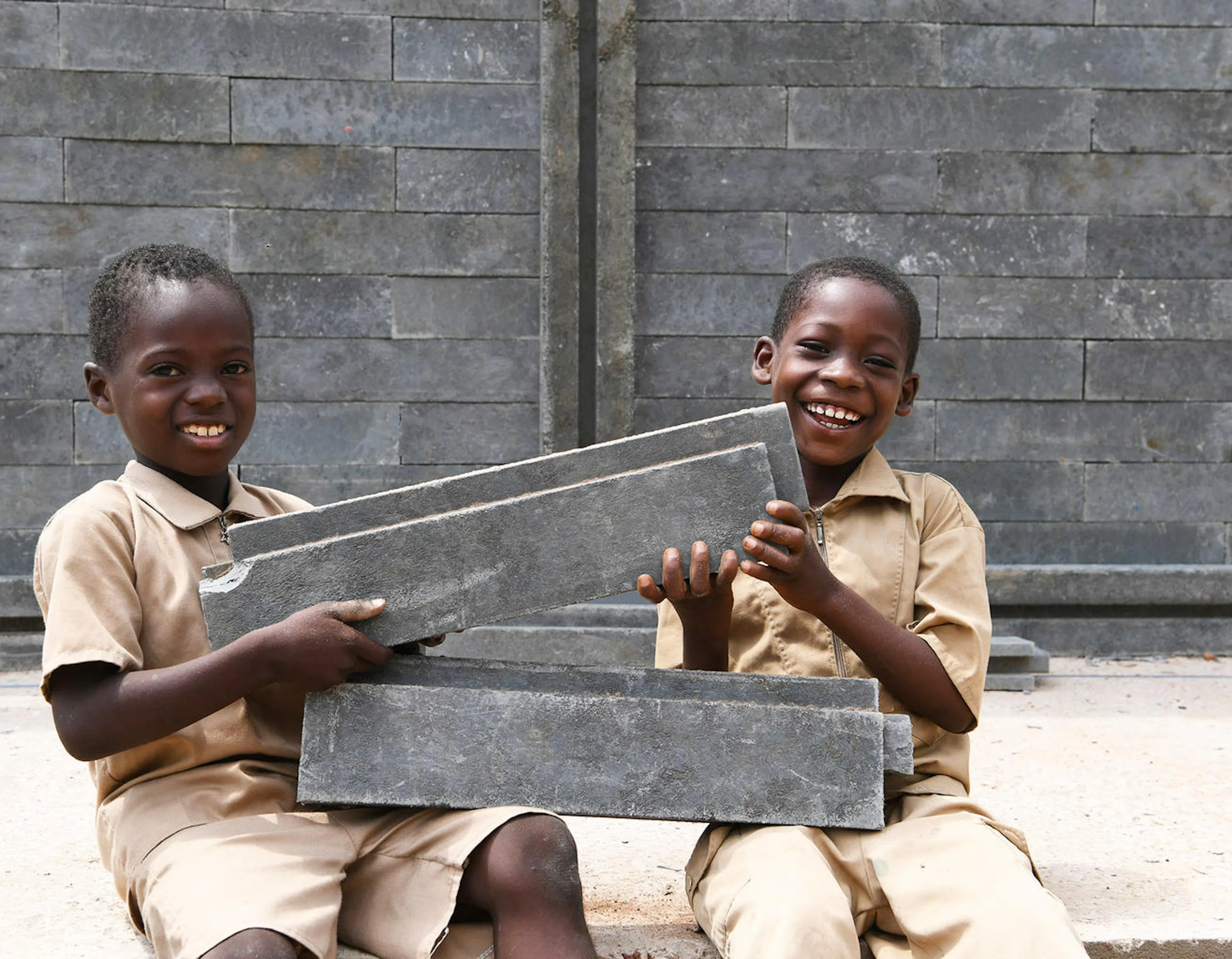 Students are happy a new class is being built at their school in Sakassou, in the center of Côte d'Ivoire. The classes are built with plastic bricks. 