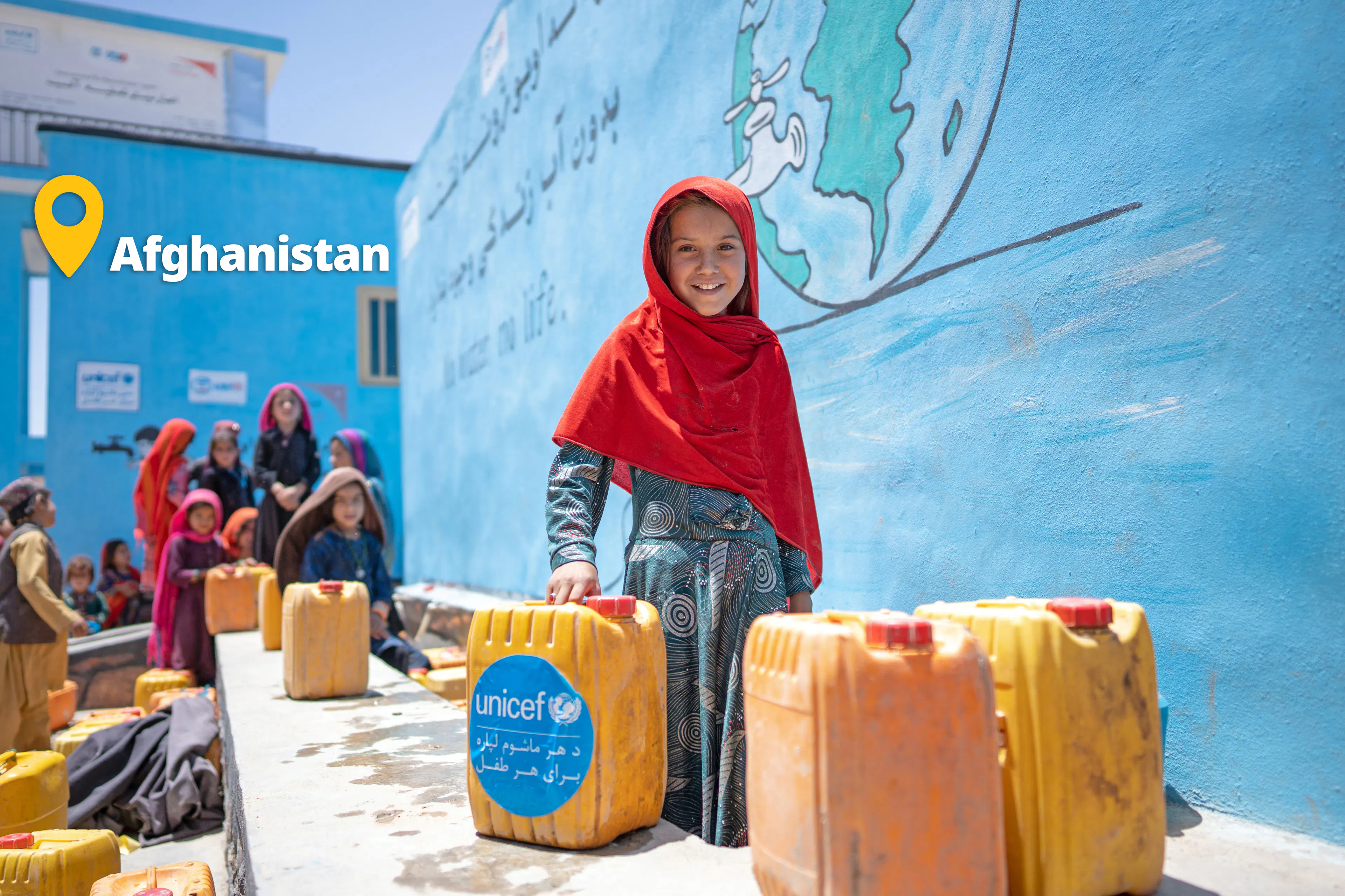 girl holding water supply in afrghanistan