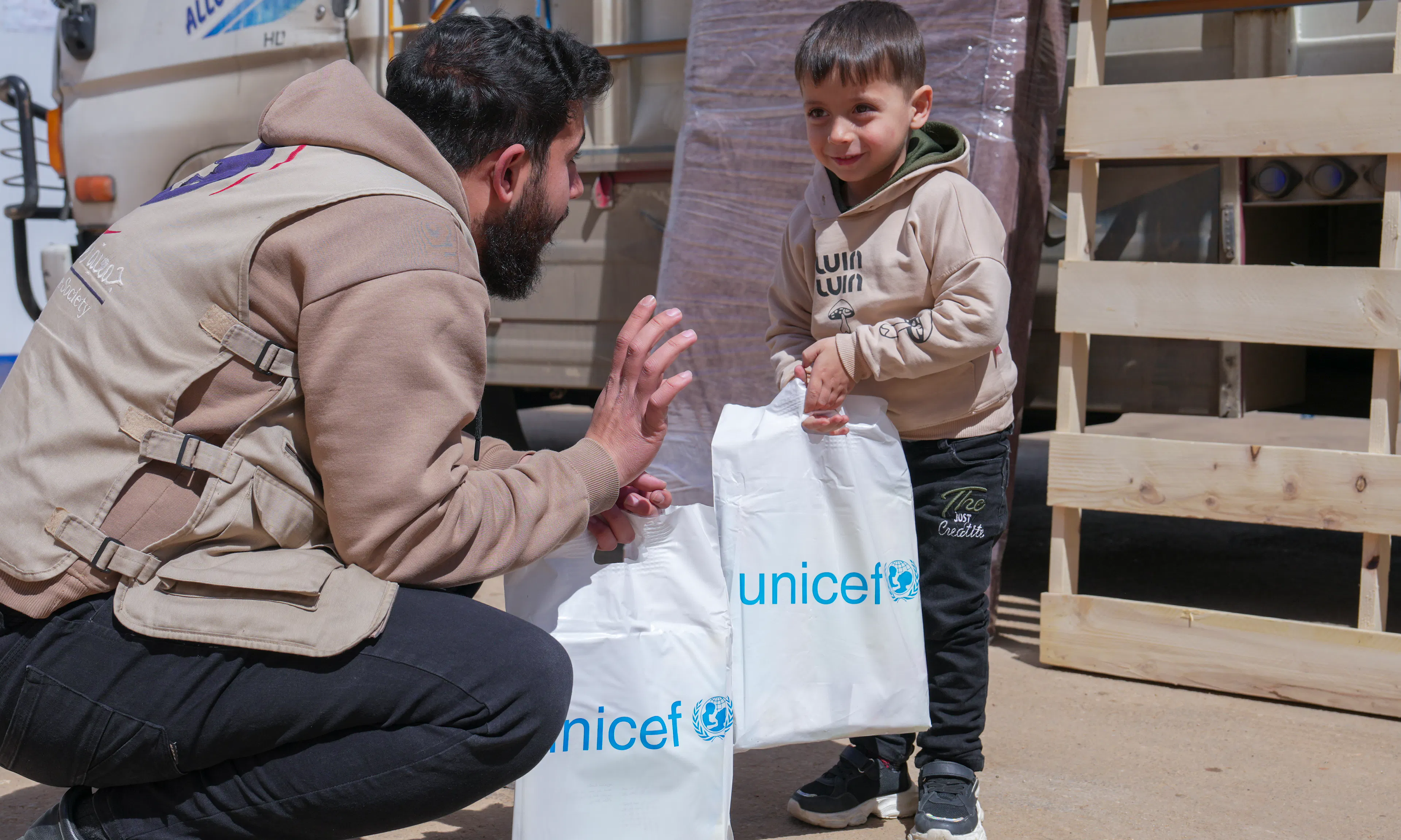 Motaz, 5, receives a mine risk education kit by a UNICEF-supported worker at the Joussieh border crossing in Homs Governorate, Syria, on 30 March 2026.