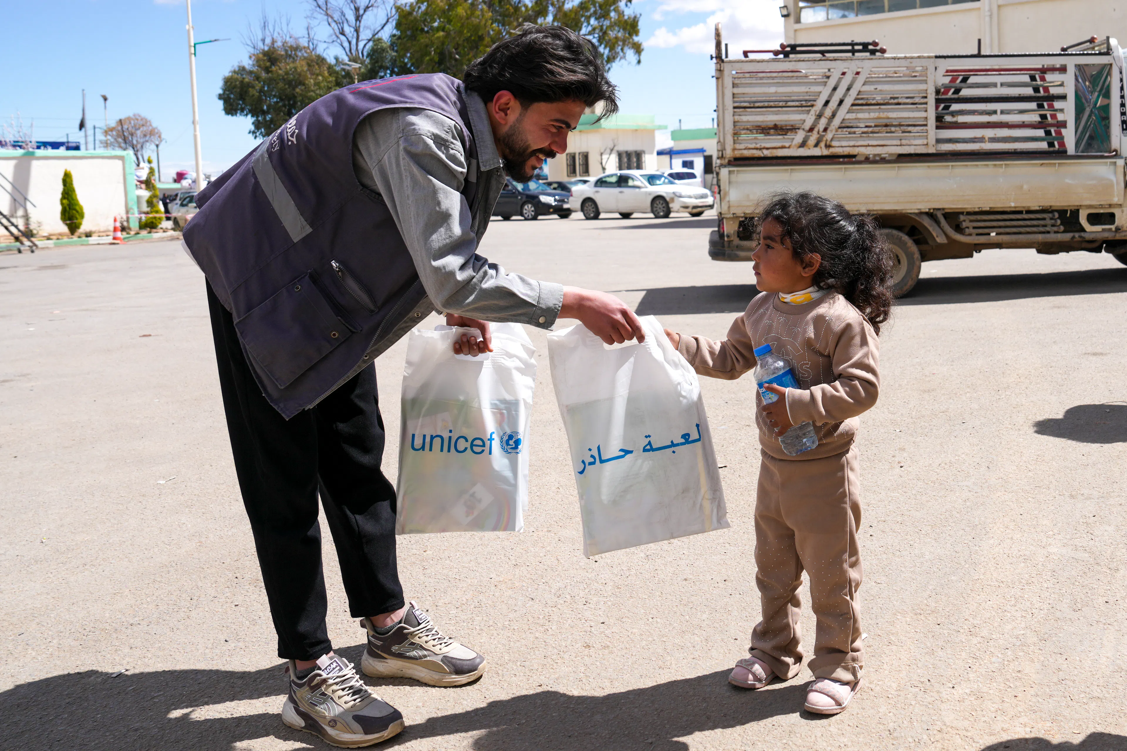Kamar, 4, receives a mine risk education kit from a UNICEF-supported worker at the Joussieh border crossing in Homs Governorate, Syria, on 30 March 2026.