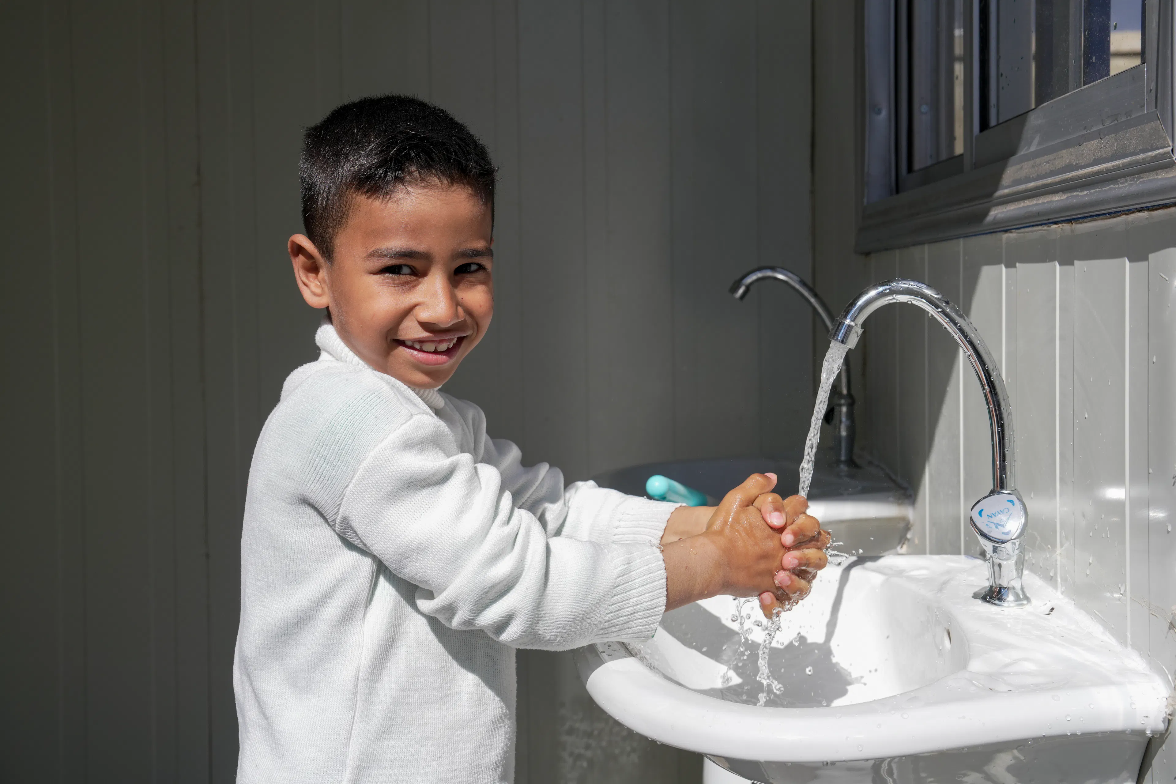 Mohamed, 6, who recently arrived with his family from Lebanon, washes his hands at a UNICEF-rehabilitated water facility at the Joussieh border crossing, Homs Governorate, Syria on 30 March 2026.