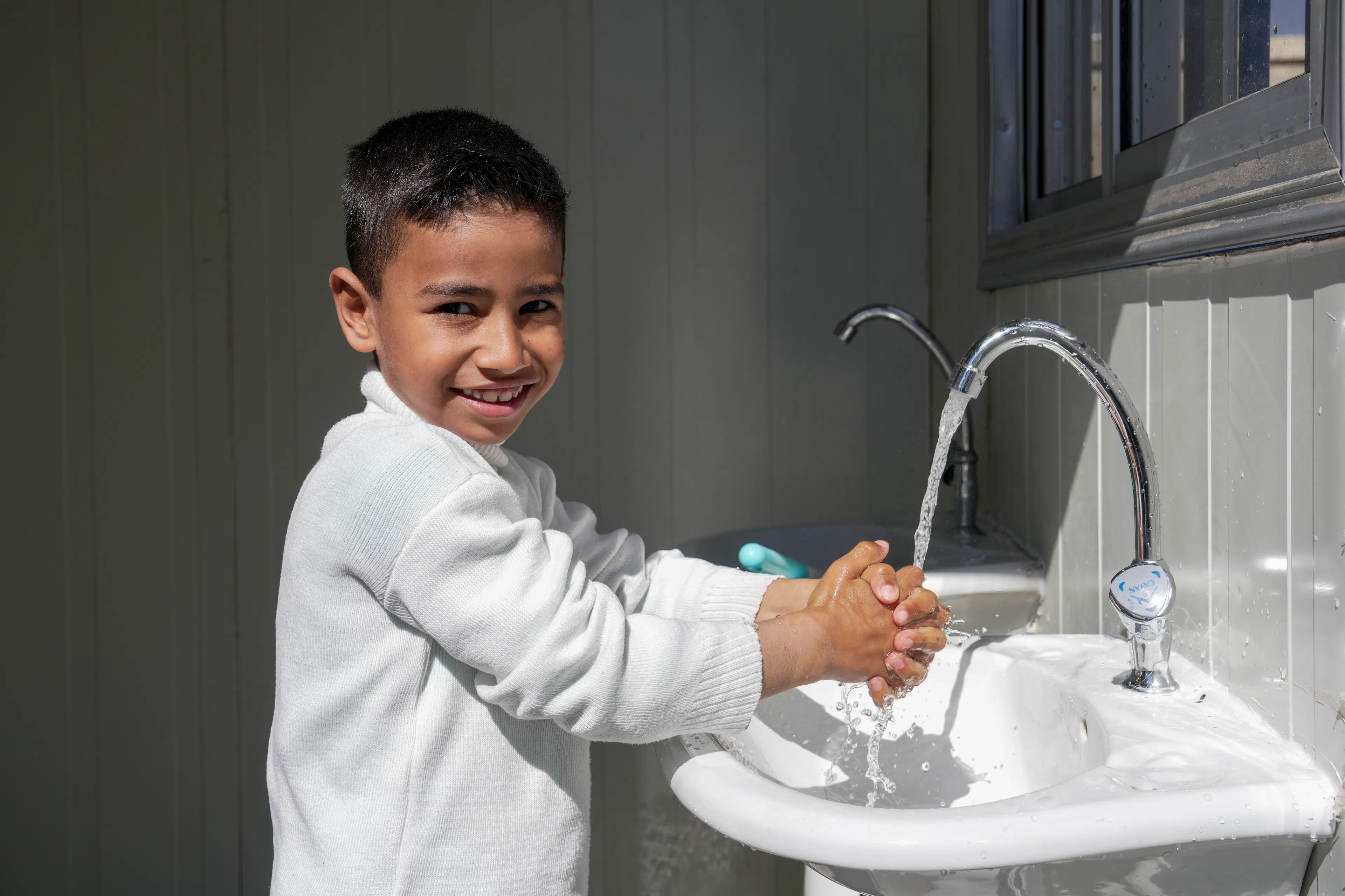 Mohamed, 6, who recently arrived with his family from Lebanon, washes his hands at a UNICEF-rehabilitated water facility at the Joussieh border crossing, Homs Governorate, Syria on 30 March 2026.