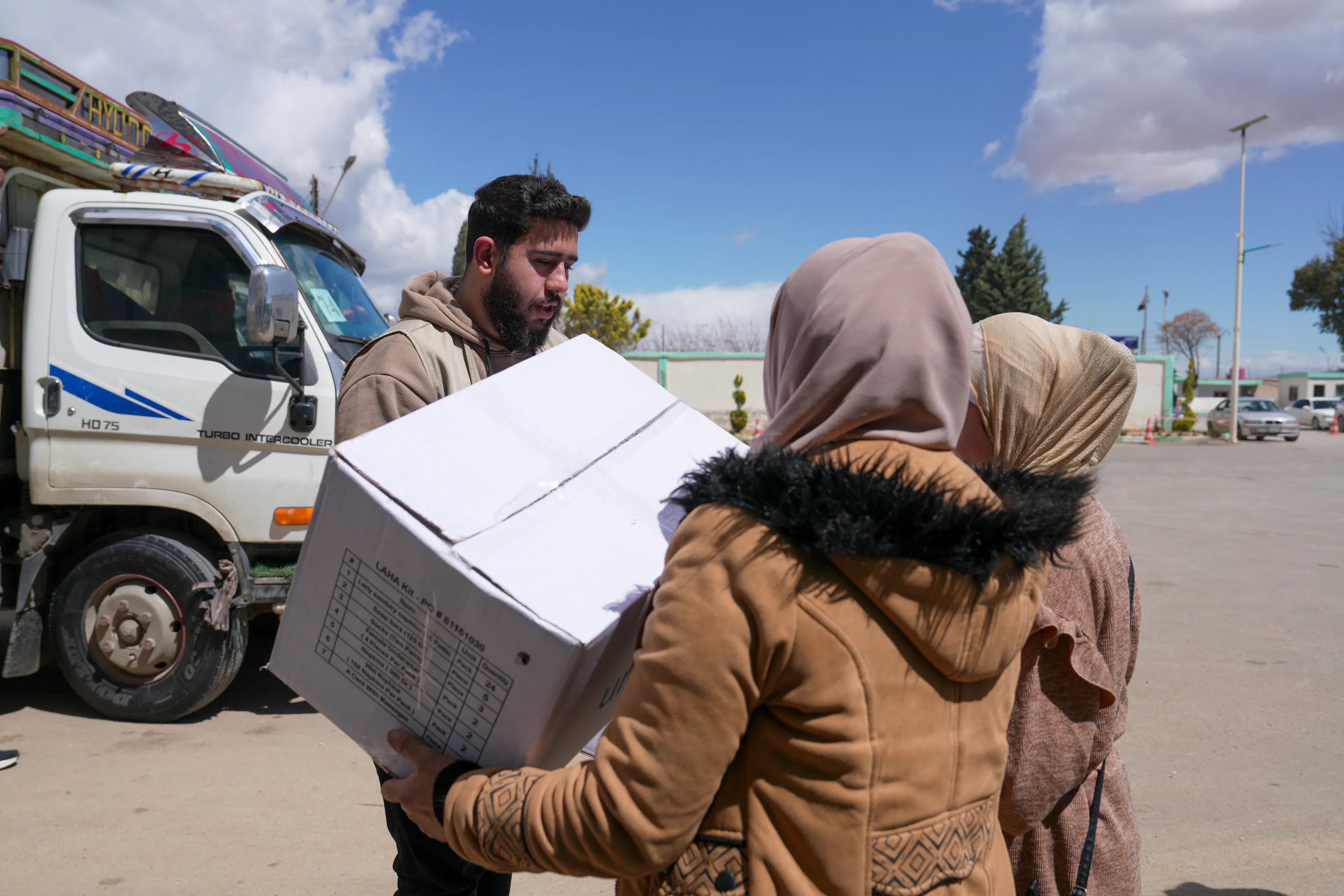 Aisha and her daughter, receives dignity kits from a UNICEF-supported worker at the Joussieh border crossing in Homs Governorate, Syria, on 30 March 2026.
