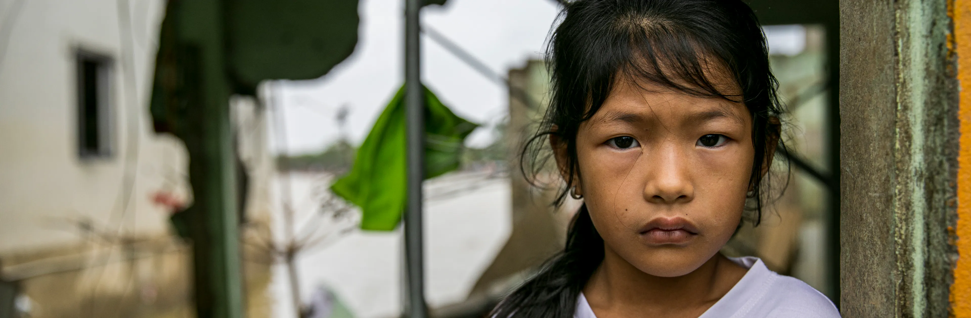Nguyen Chau Hai Yen, 9 years old, stands in her collapsed house in Vietnam.