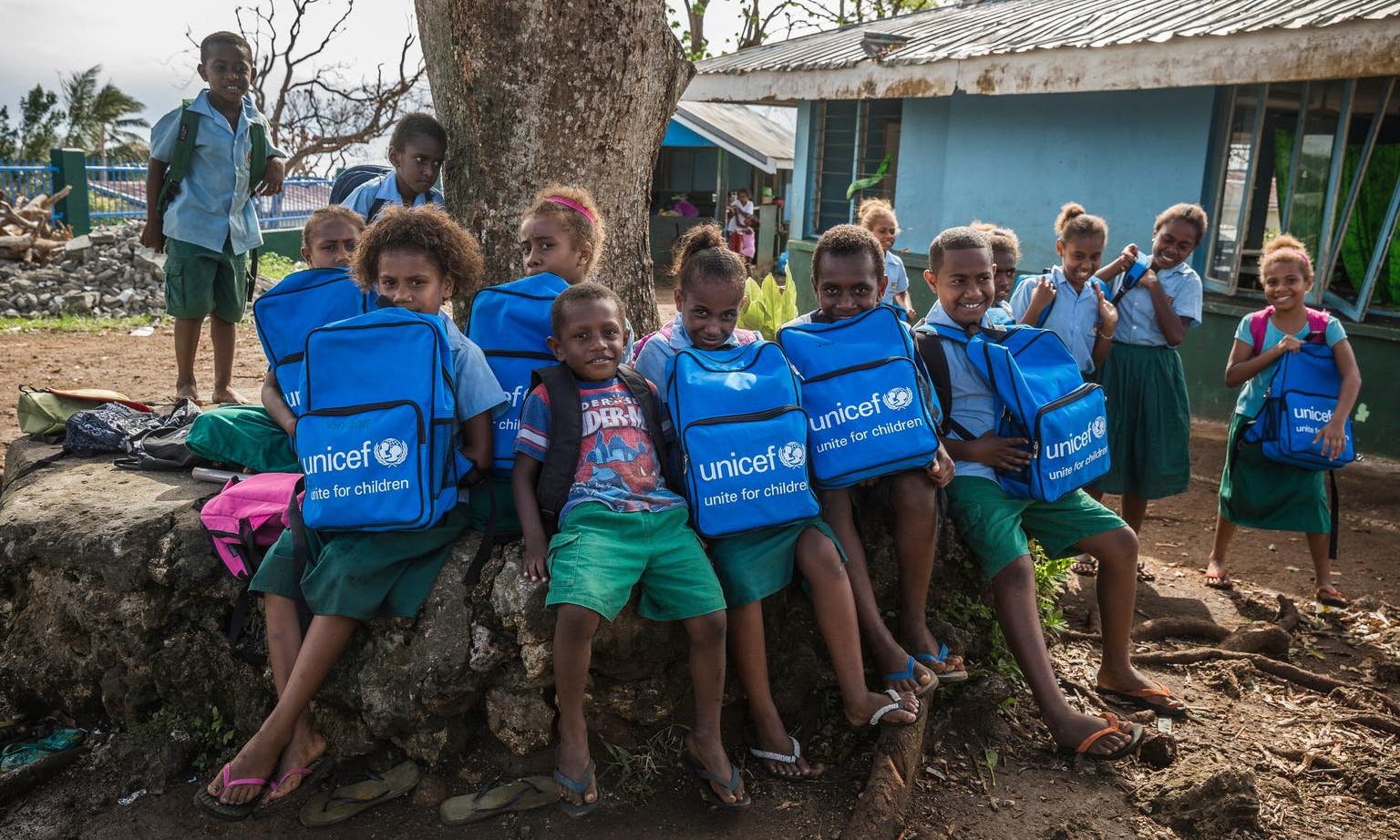 Children in Vanuatu proudly display the school bags they've received from UNICEF