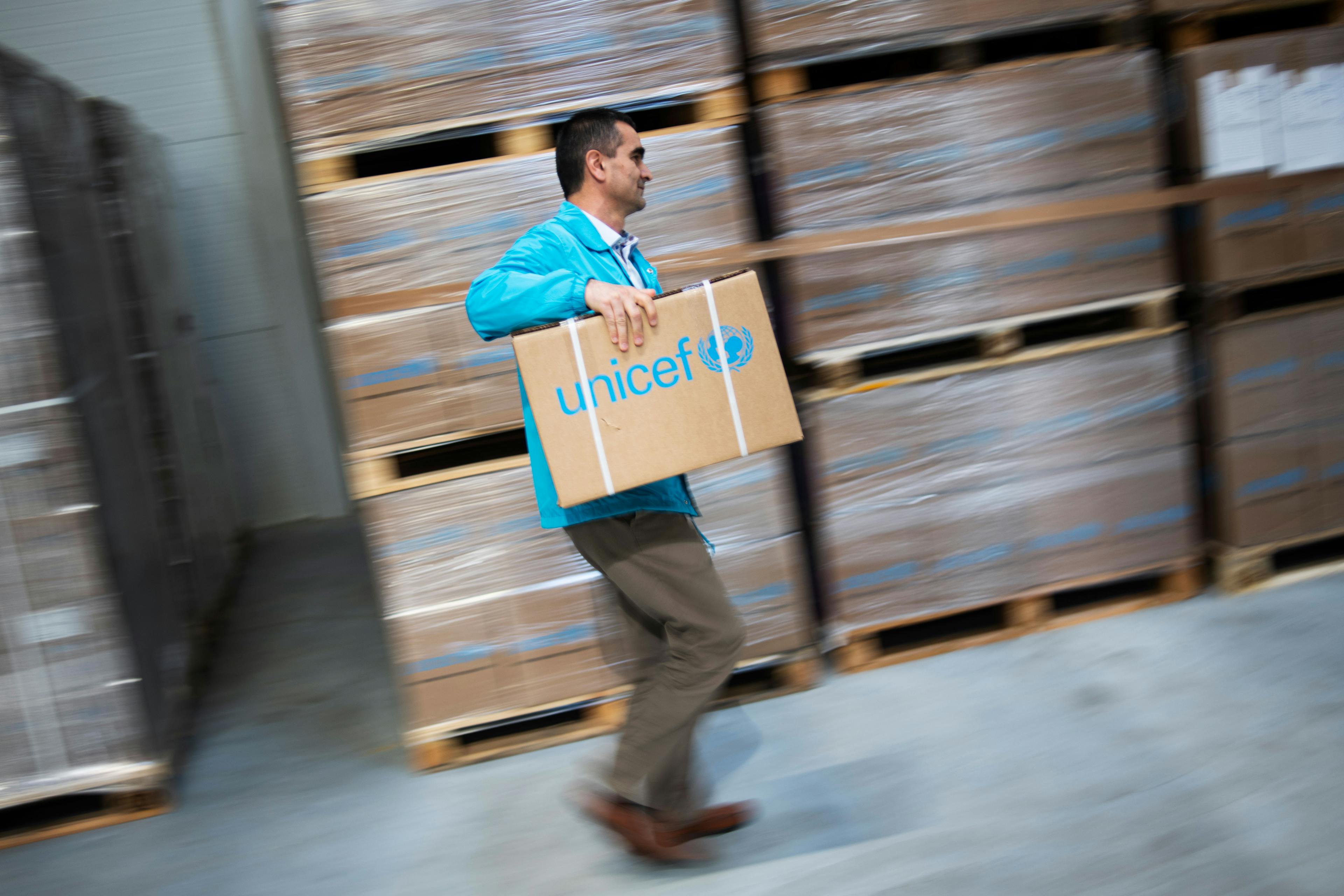 A UNICEF employee moving a box in the warehouse