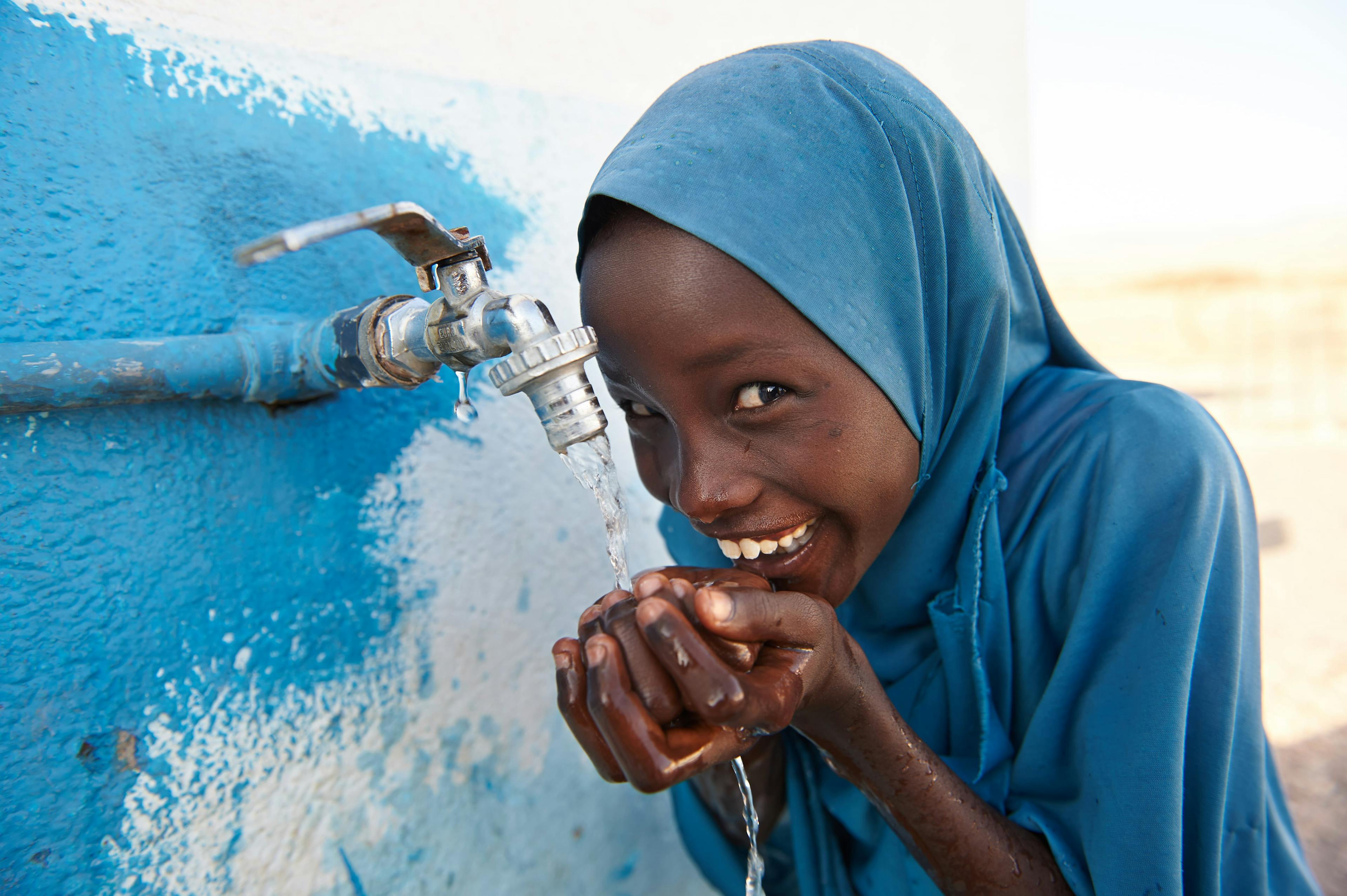 About Us - a girl child drinks safe water from a tap outside a UNICEF supported school in the village of Dafo, situated 5 km from the city of Tadjourah, in the southern Djibouti