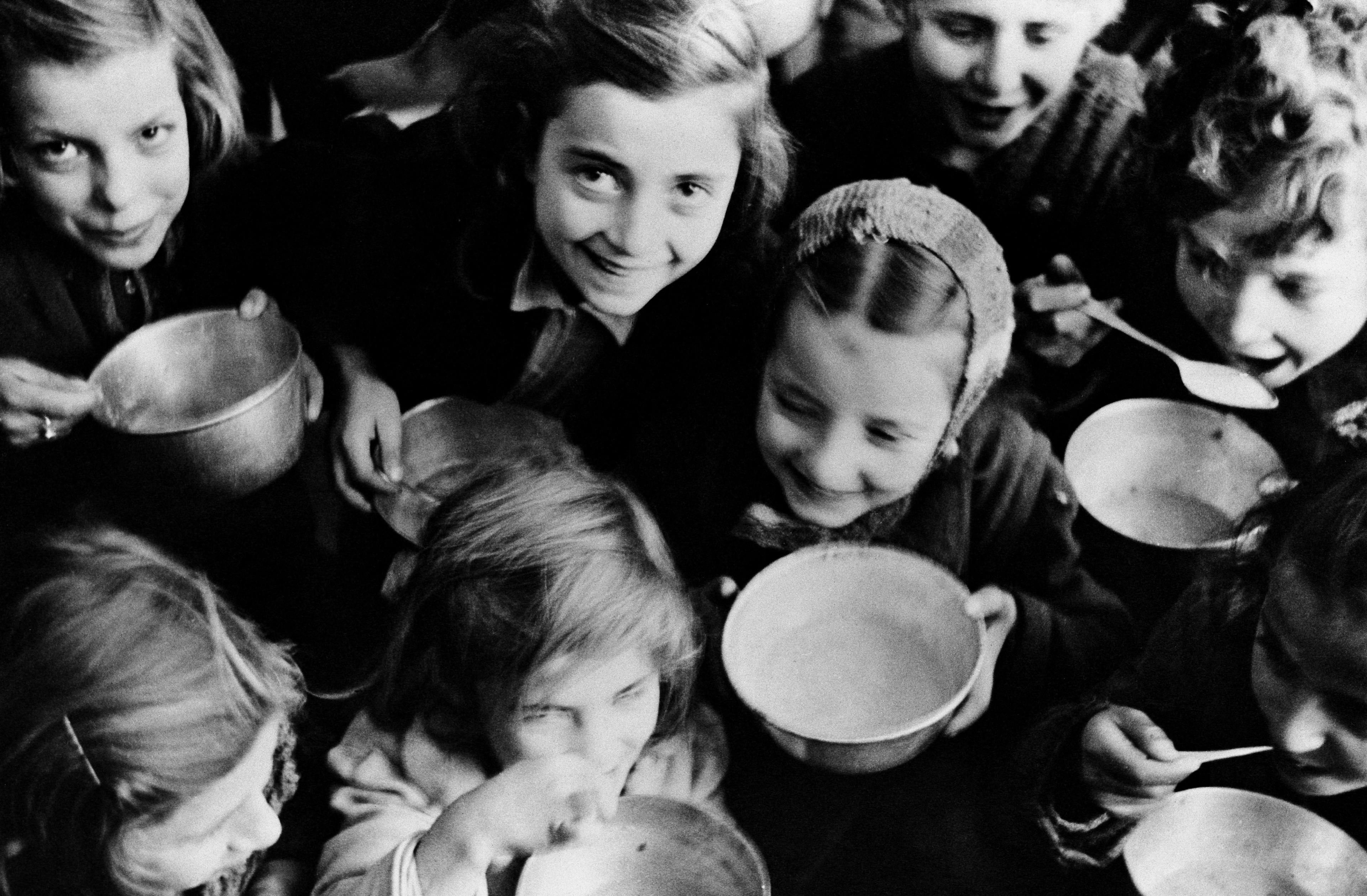 Circa 1946 in Greece, smiling girls of Patras, a north-western port city, eat their first UNRRA-provided meal from metal bowls.