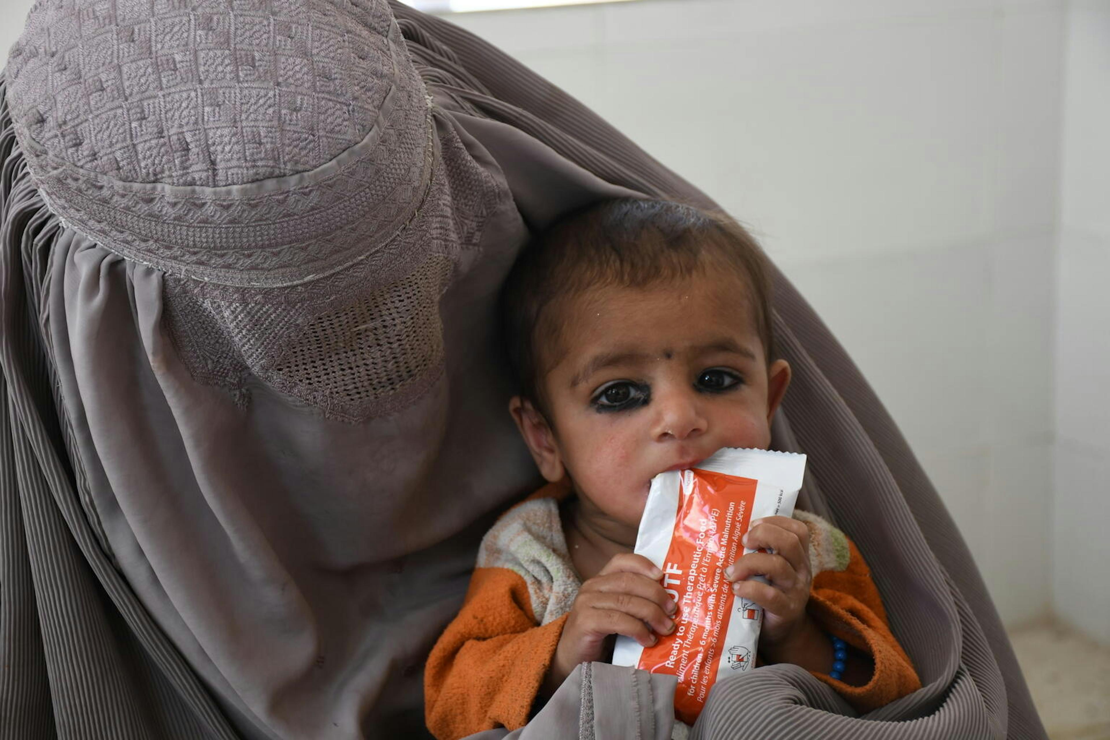 A baby boy in Kandahar, Afghanistan eats a sachet of ready-to-use therapeutic food. He is being treated for severe acute malnutrition at Mirwais Regional Hospital.