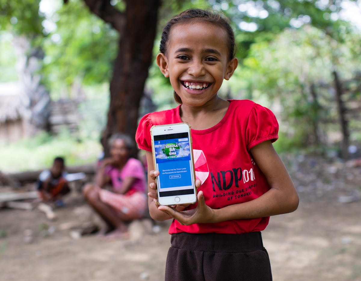 Education- A girl shows off the online platform on which children and parents in Timor-Leste can access a range of audio-visual material to help students continue learning during ongoing school closures