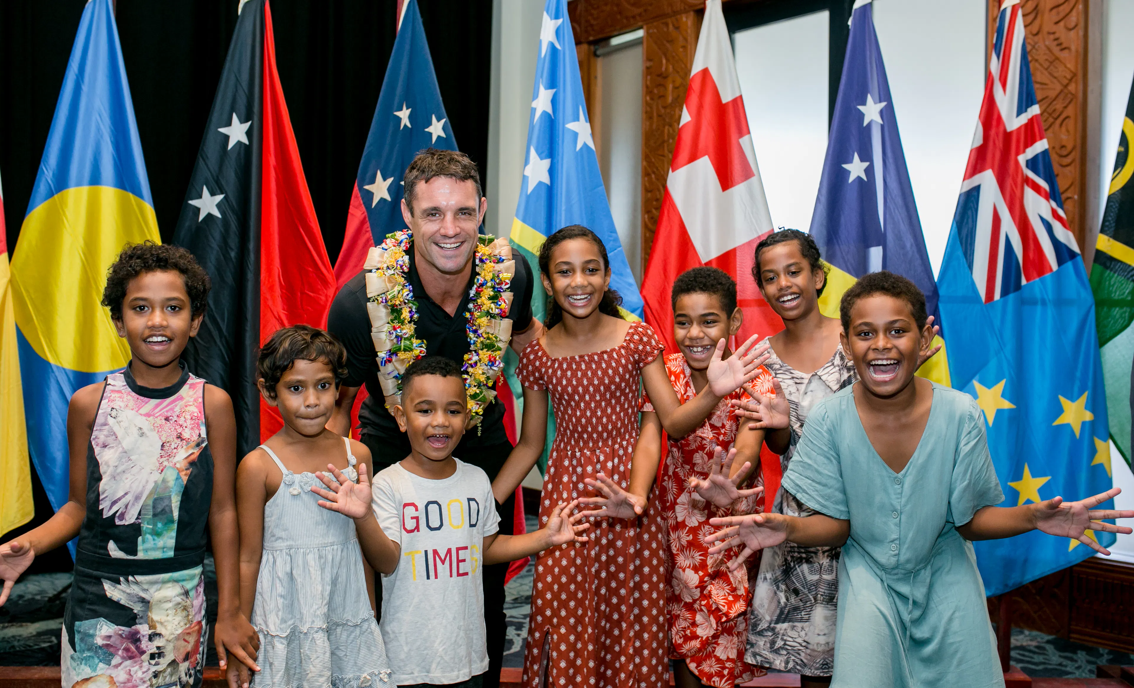 Dan Carter smiling with kids from the Pacific 