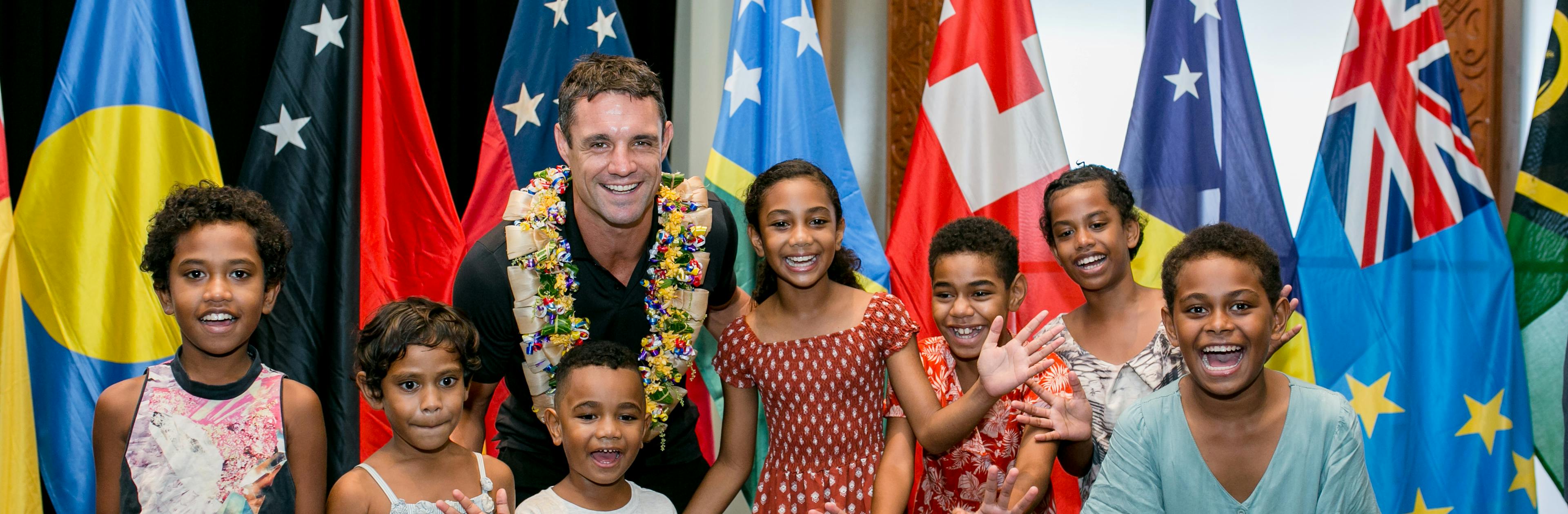 Dan Carter smiling with kids from the Pacific 