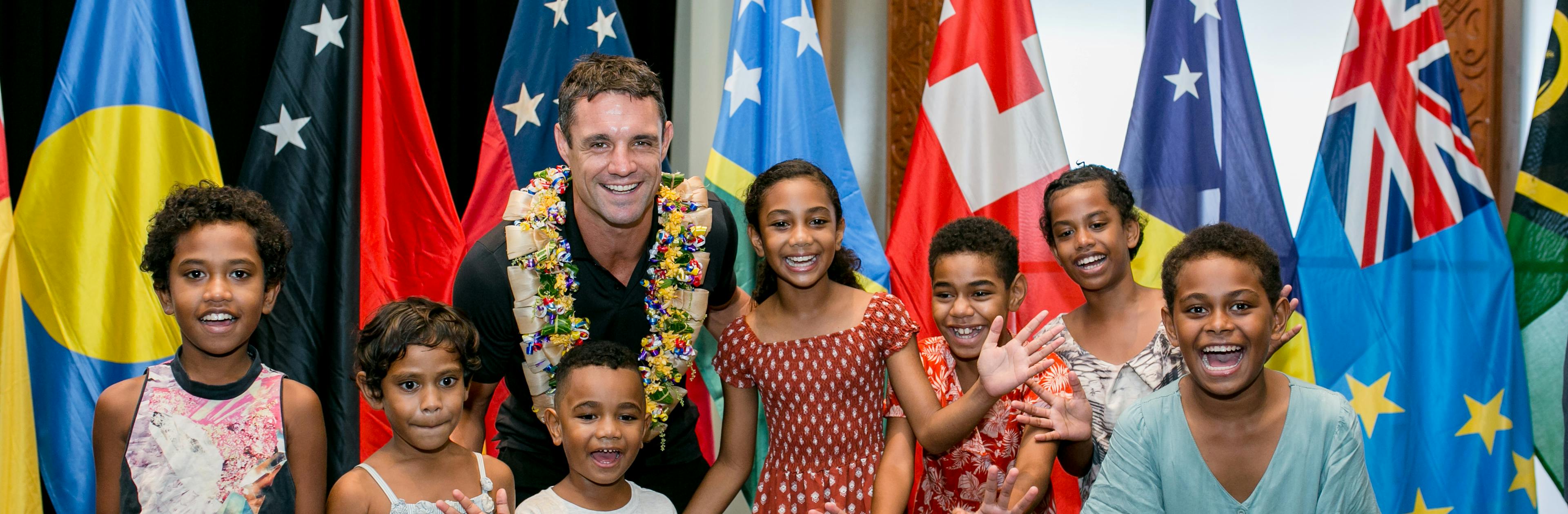 Dan Carter smiling with kids from the Pacific