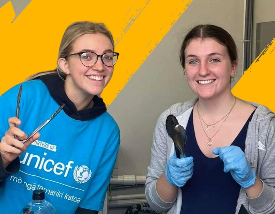 UNICEF Aotearoa fundraisers holding sausage sizzle