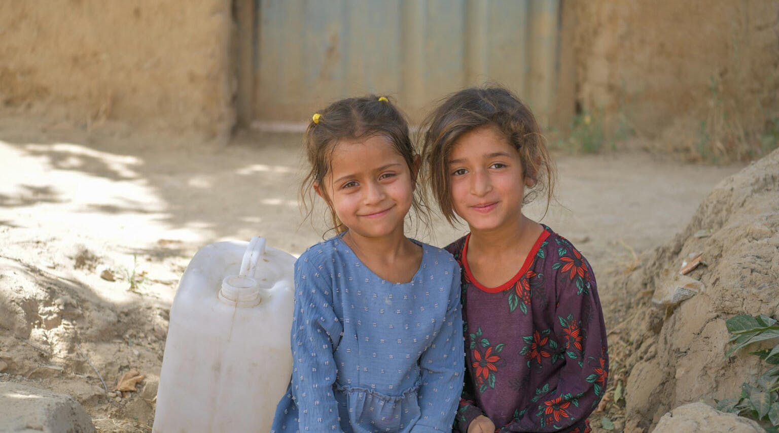 Afghanistan Emergency, Sahar and Hasina (both 6) collect dirty water from a stream for their families in Chamtal, Afghanistan.