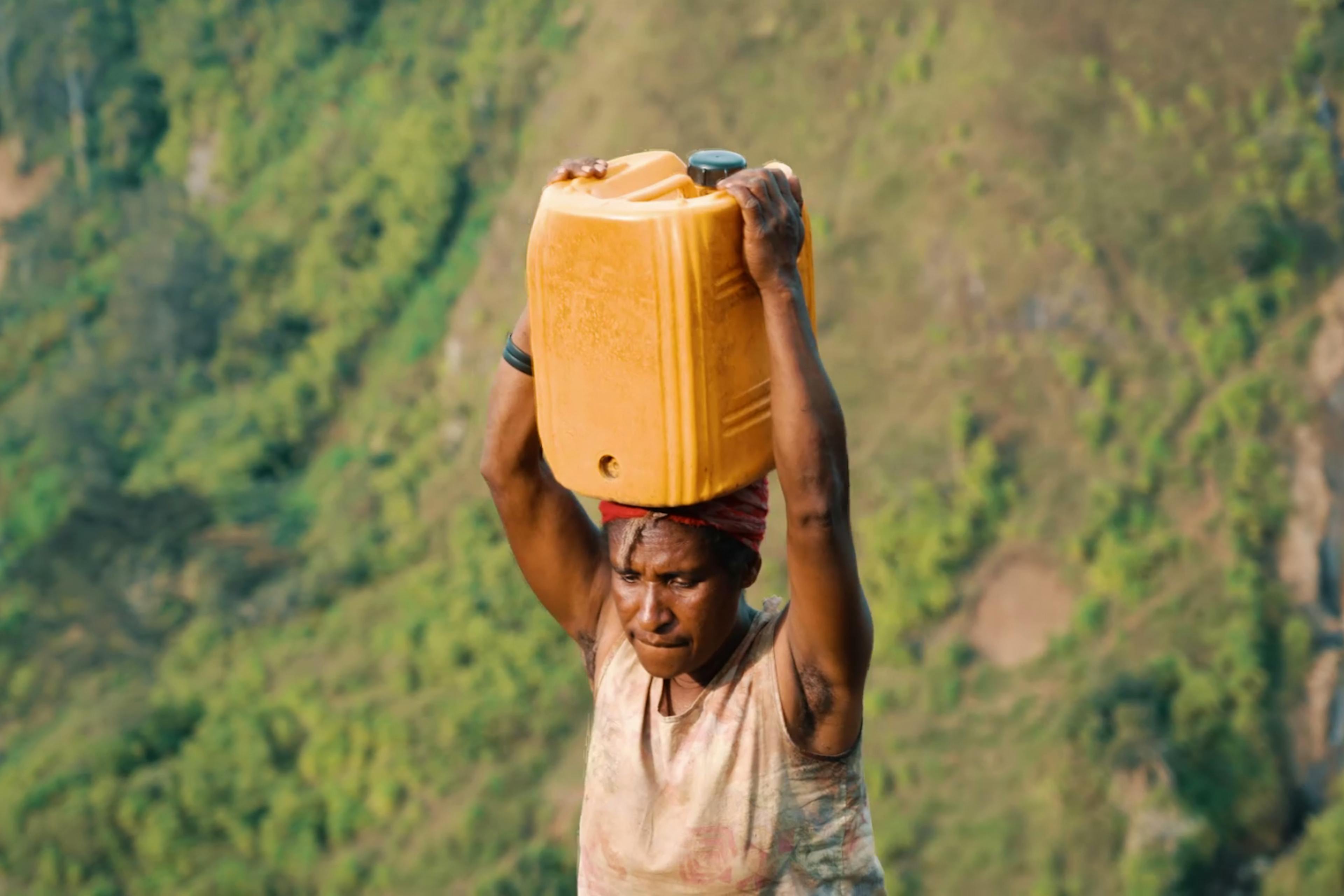 Carrying jerrycan filled with water. 
