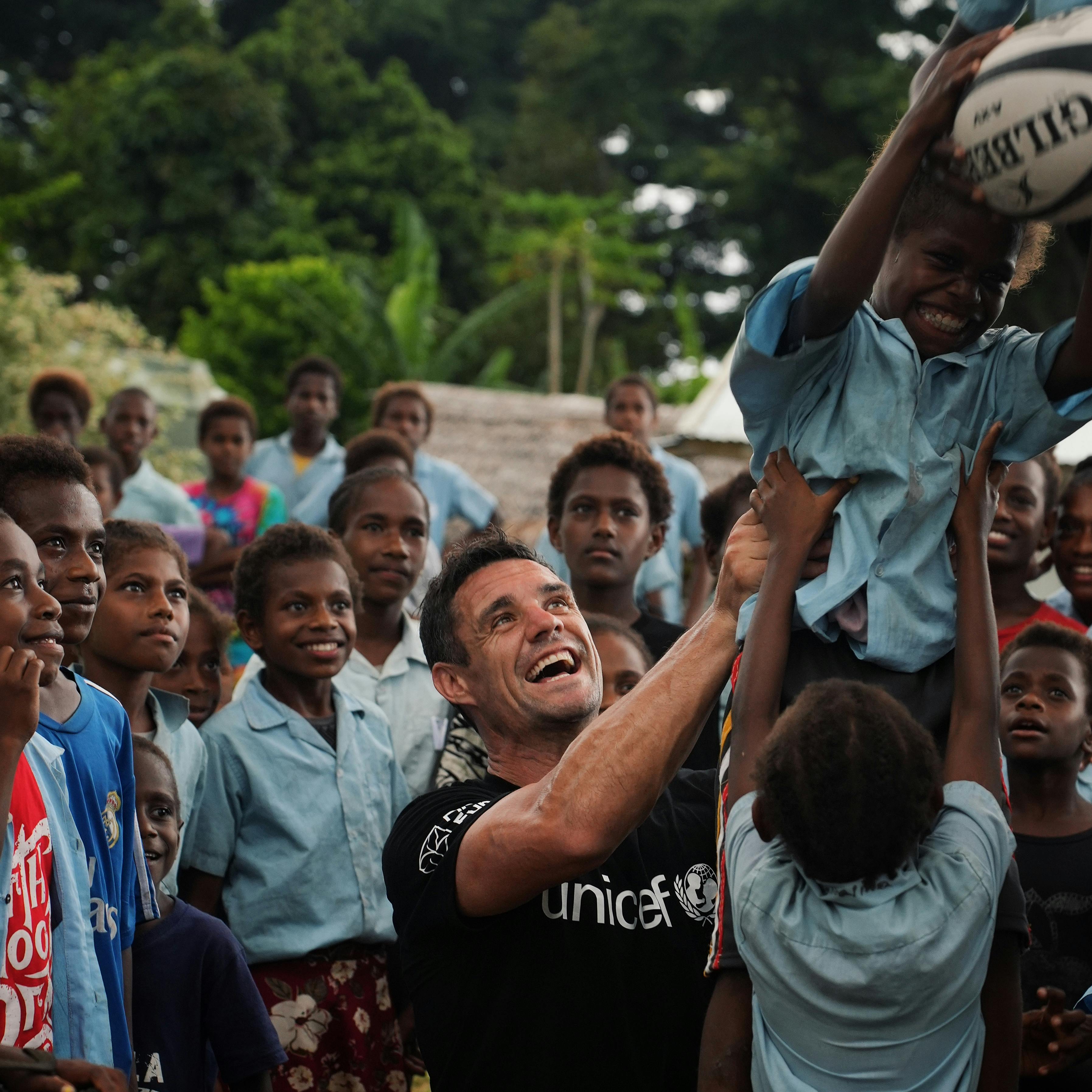 Dan Carter playing rugby with kids in the Pacific