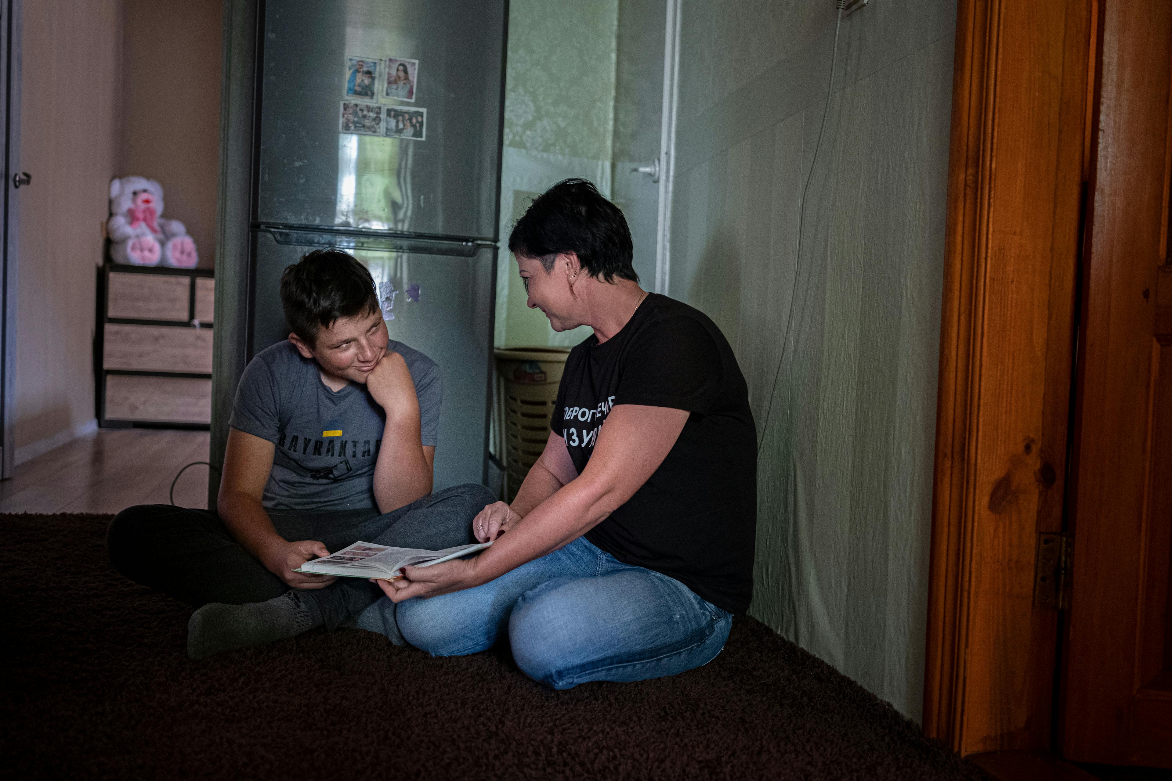On 13 August 2022, Nazar, 13, and his mother, Alina, show how they studied when fighting was taking place around their home, in the village of Olyzarivka, Ukraine.
